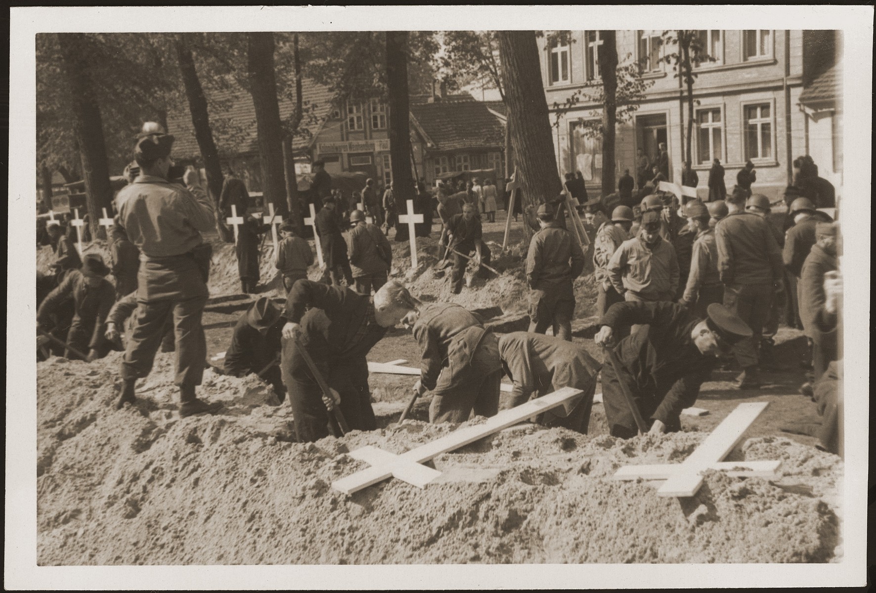 The population of Ludwigslust digs graves on the palace grounds of the Archduke of Mecklenburg, where they have been forced by U.S. troops to bury the bodies of prisoners killed in the Woebbelin concentration camp.