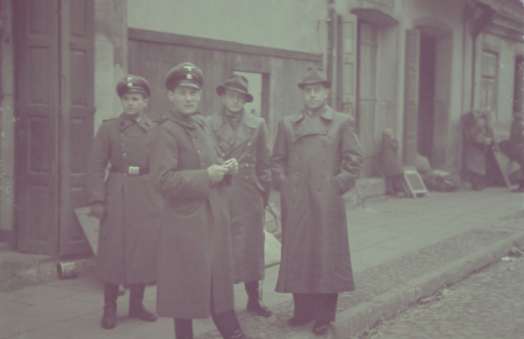 Two SS men gather with two other Germans on a street in the Lodz ghetto.