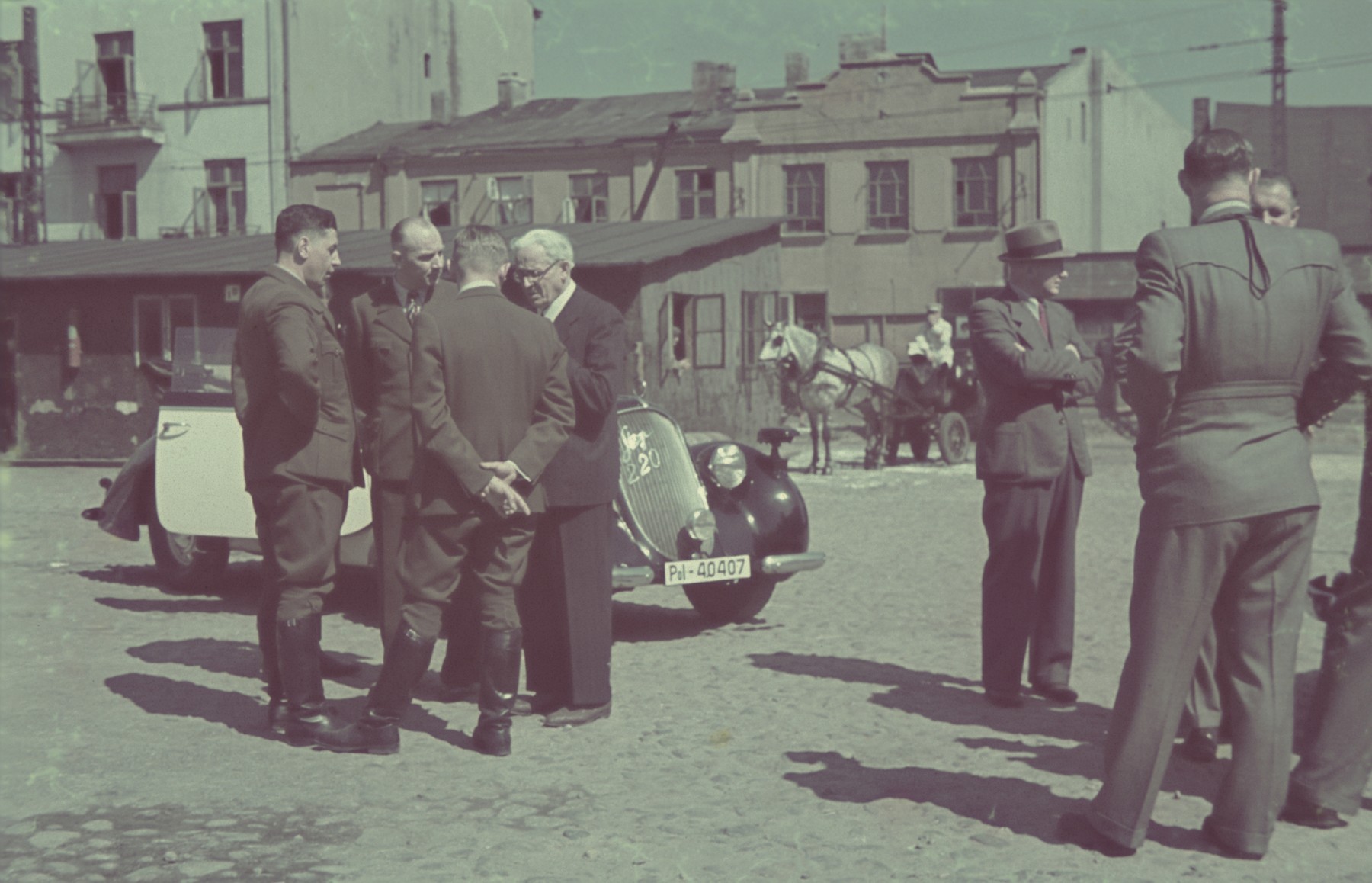 Mordechai Rumkowski meets with German officials on a street of the Lodz ghetto.

Original German caption:#163.