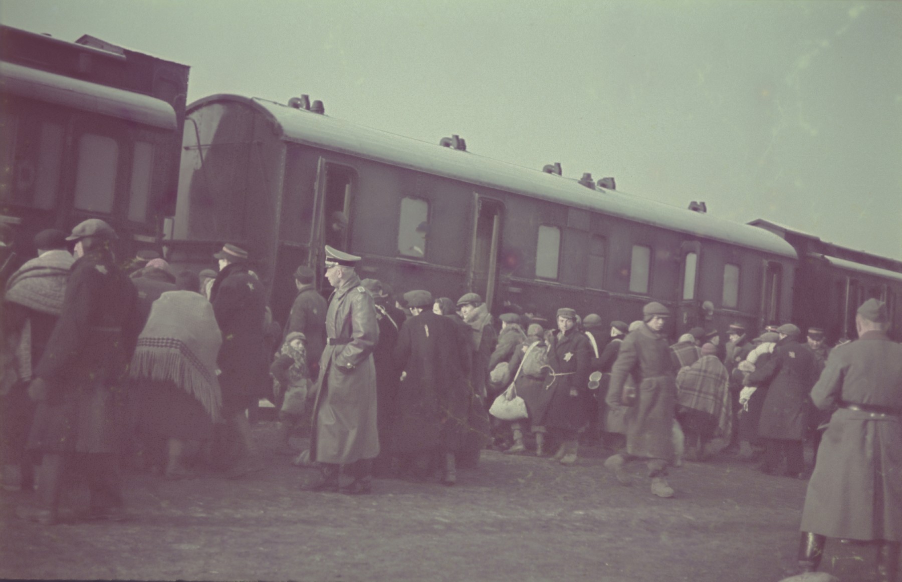 Jews board a passenger train during a deportation action in the Lodz ghetto.

Original German caption: "Judenaussiedlung" (Jewish resettlement), #153.