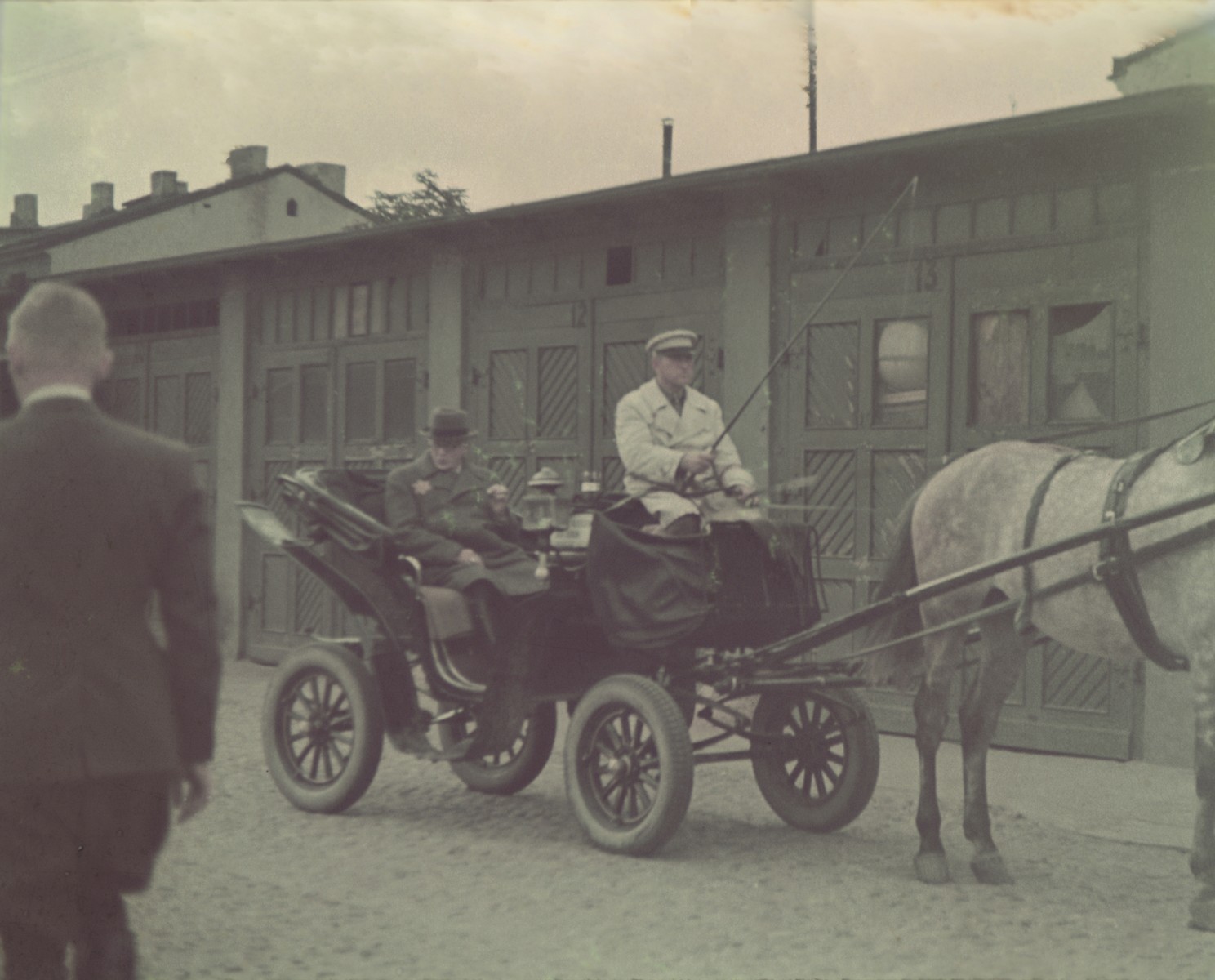 Mordechai Rumkowski rides through the Lodz ghetto in a horse-drawn carriage.

Original German caption: "Judenaeltester" (Jewish elder).