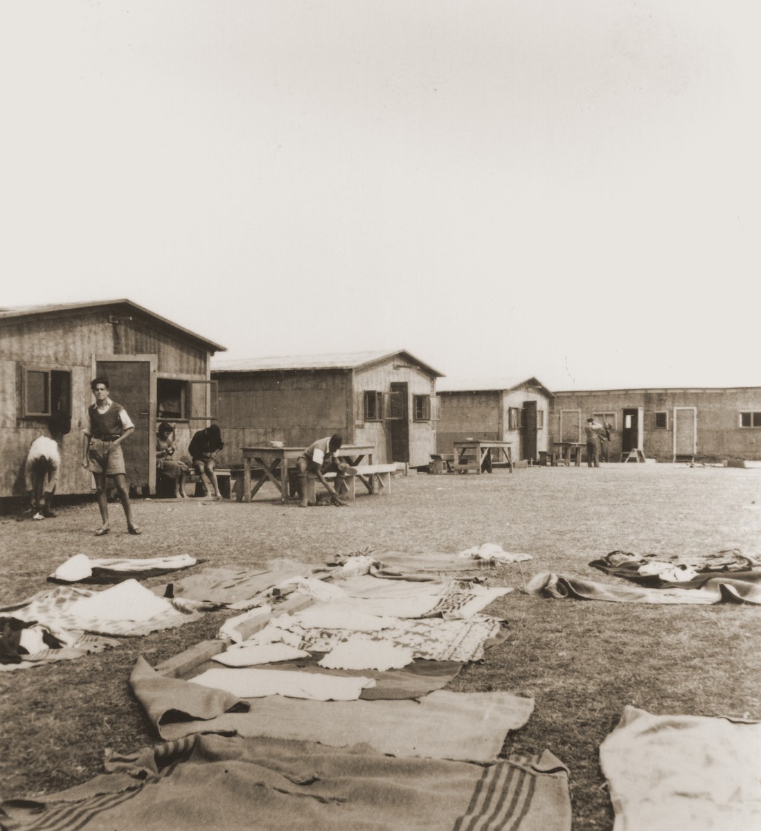 At a refugee camp established for members of the Kladovo transport, Zionist youth perform their daily tasks in front of their barracks.