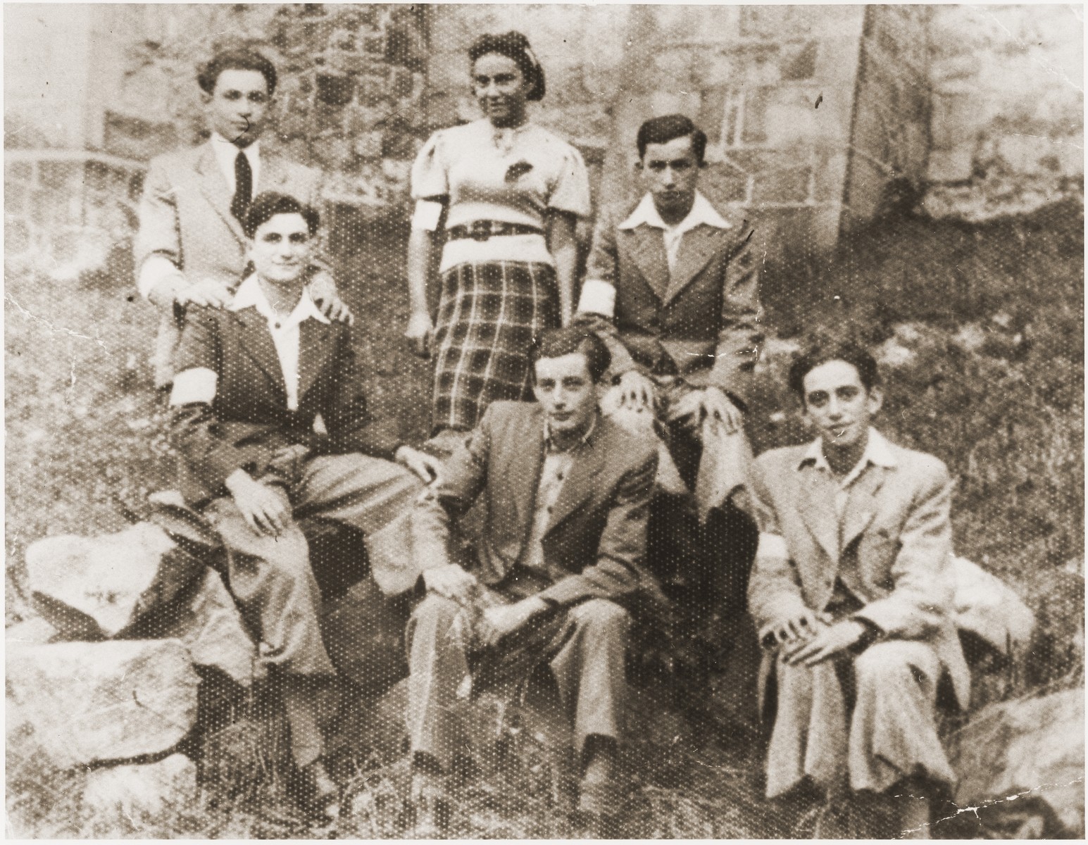 Group portrait of members of the Akiva Zionist youth group wearing armbands in the Wisnicz ghetto.

Among those pictured are: William Wiener, Sala Schoen, Maniek Wiener and Meyer Schoen.
