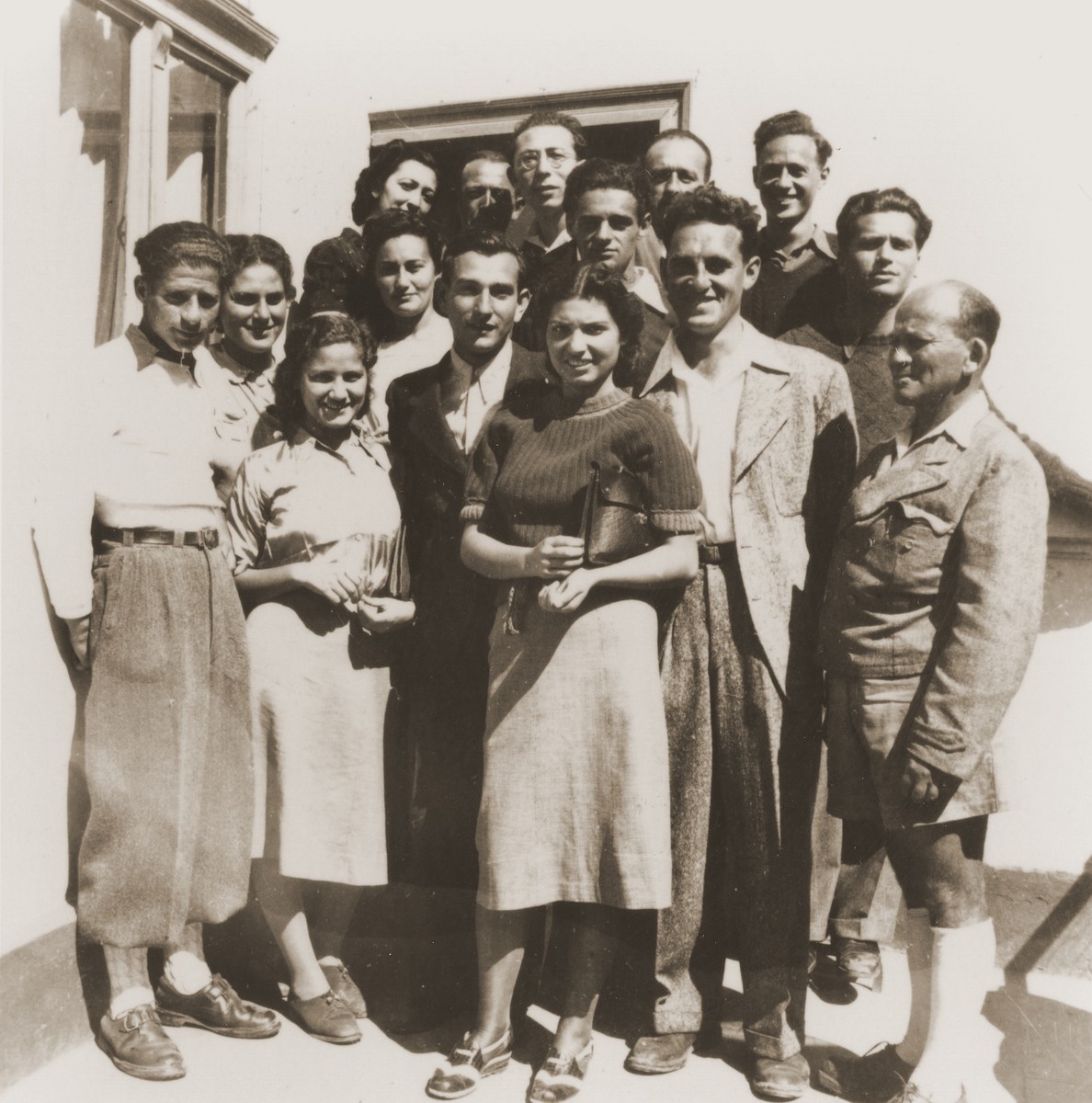 Group portrait of Zionist youth from the Kladovo transport taken after the triple wedding of members of their group.  

Among those pictured are: Erich Nachhaeuser (far left), Jukl Dorfmann (top row, middle, wearing glasses), and Klara-Shula Dorfmann (middle row, second from left).