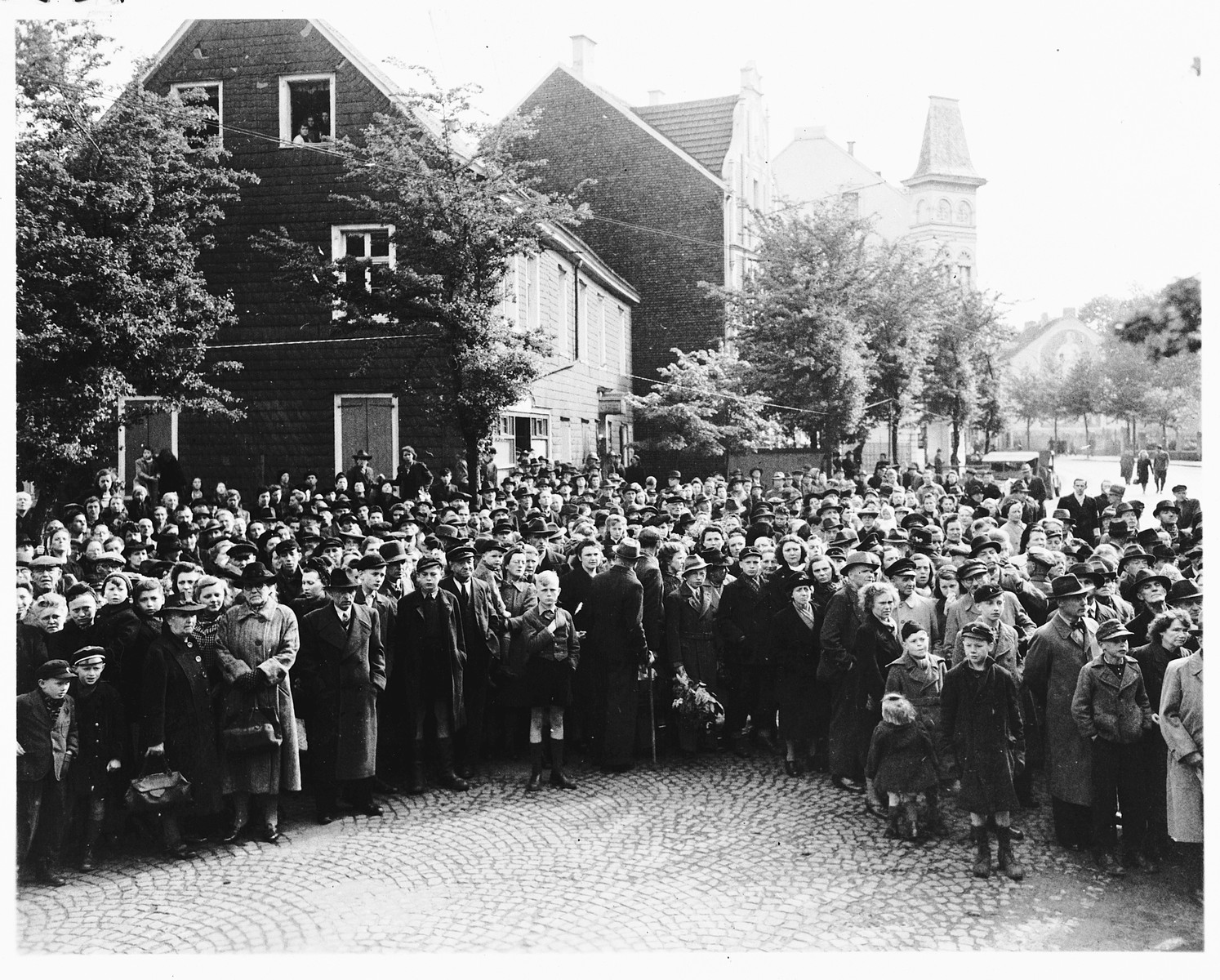 German civilians attend funeral services for the 71 political prisoners, exhumed from a mass grave near Solingen-Ohligs, reburied in front of the city hall.  

The victims, most of whom were taken from Luettringhausen prison, were shot and buried by the Gestapo following orders to eliminate all Reich enemies just before the end of the war.