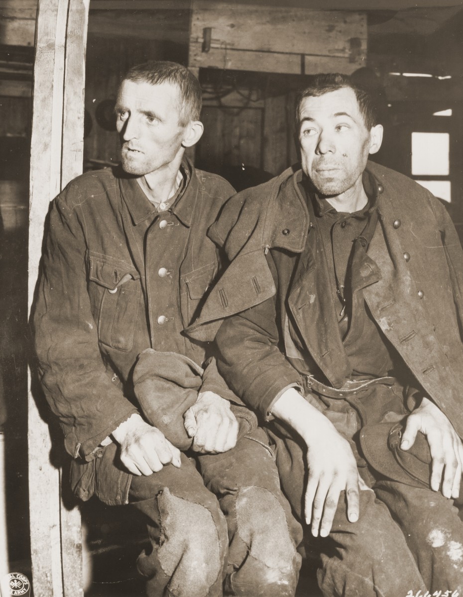 Two emaciated Soviet POWs sit on a bunk inside a barracks in the newly liberated Hemer POW camp.

Original caption: "Two former Soviet POWs display the effects of camp imprisonment through their appearence. The man on the left is so thin and weak from starvation that he can hardly stand up by himself. The other's swollen face also indicates suffering from starvation. When the 75th Infantry Division of the U.S. Ninth Army liberated the camp at Hemer, about 22,000 prisoners were liberated. Approximately 9,000 prisoners were hospitalized for tuberculosis, dysentery, malnutrition and typhus fever."