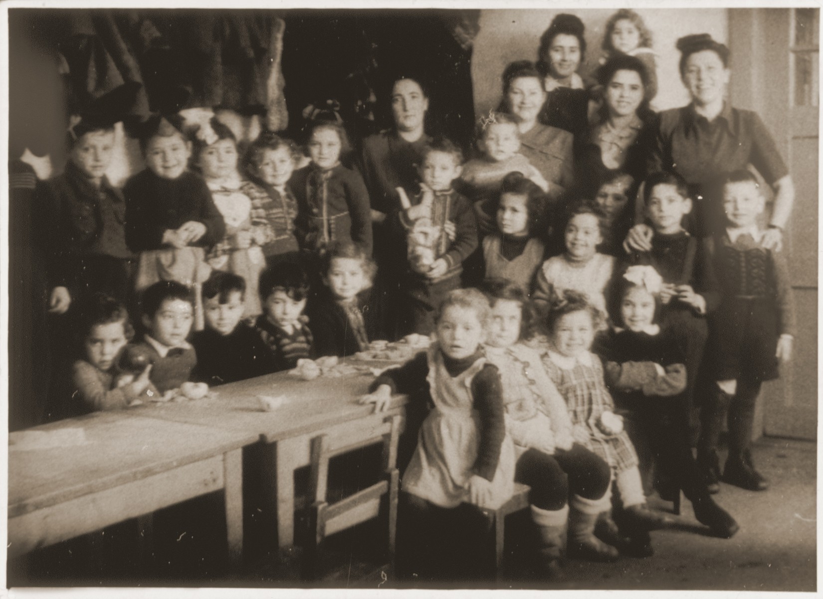 Jewish kindergarteners and five teachers and aides in a classroom at the Landsberg DP camp.  

Dorit Mandelbaum stands in the second row, third from the right.