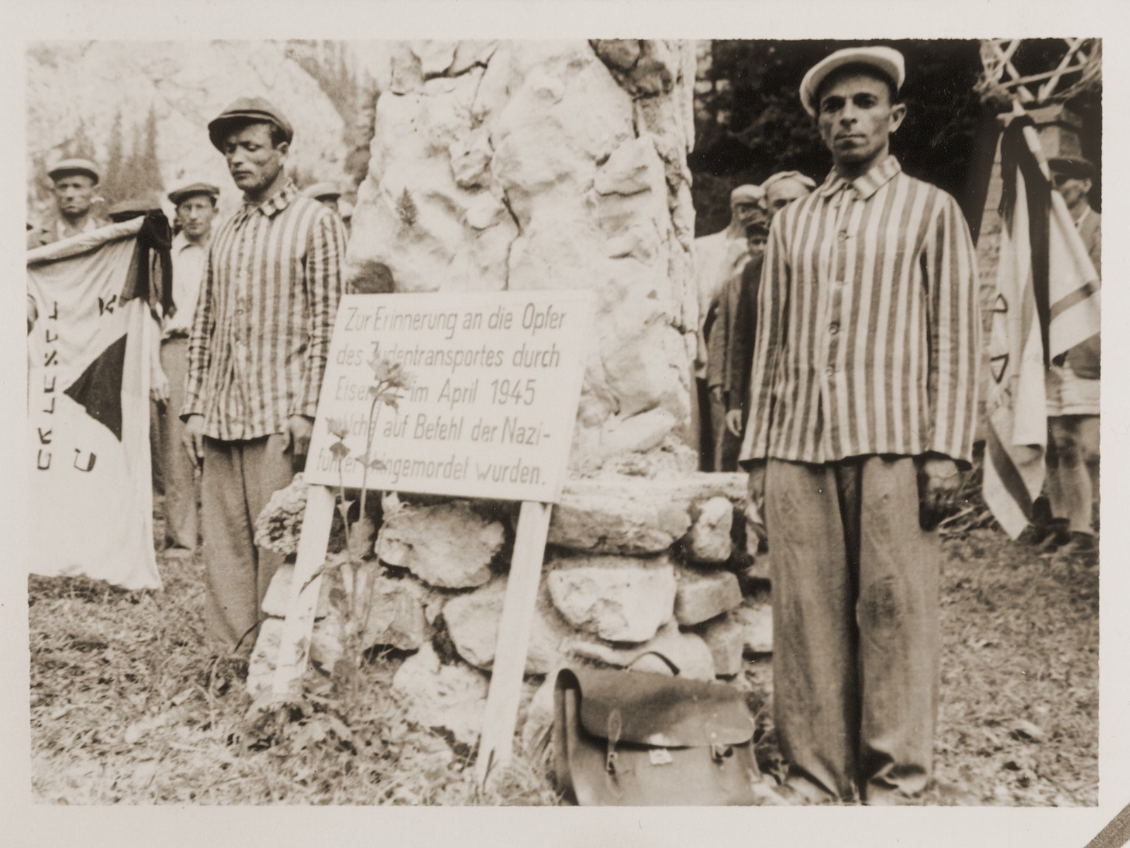 Two men wearing striped prisoner uniforms stand next to a monument memorializing Jewish transports that passed through Eisenerz. 

Family album bearing the title "Motoring/Jewish DP camp/St. Marein [Sankt Marien]/School," that belonged to Moritz Friedler.  In 1946 and 1947, he served as a social worker with the Jewish Committee for Relief Abroad at the Sankt Marien DP camp in the British zone of Austria. Friedler subsequently became the JDC's Area Director in Linz, Austria.  The photo album documents Jewish DP life in both places.