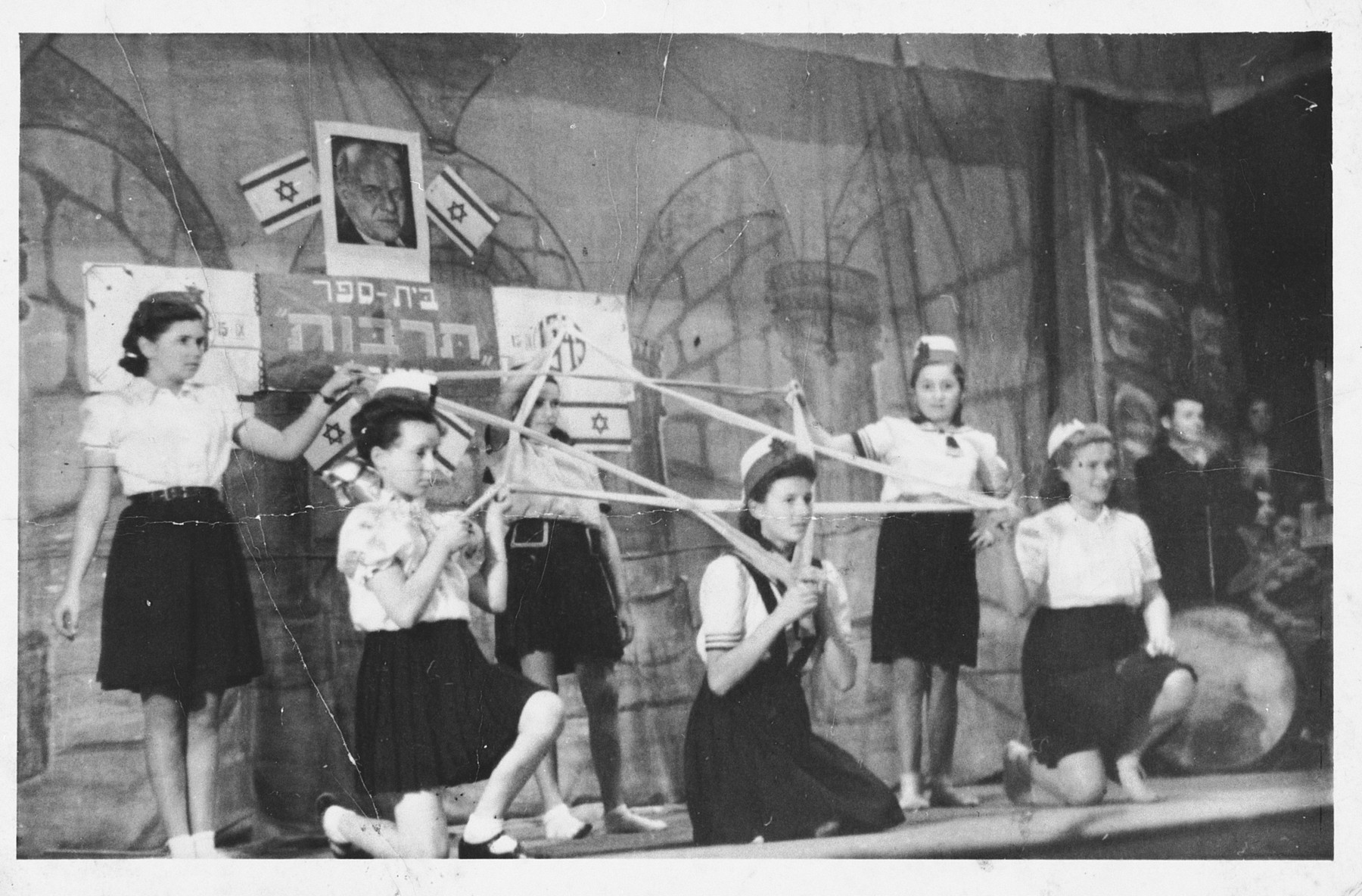 Children make a Jewish star out of ribbon during a performance at the Foehrenwald displaced persons camp.