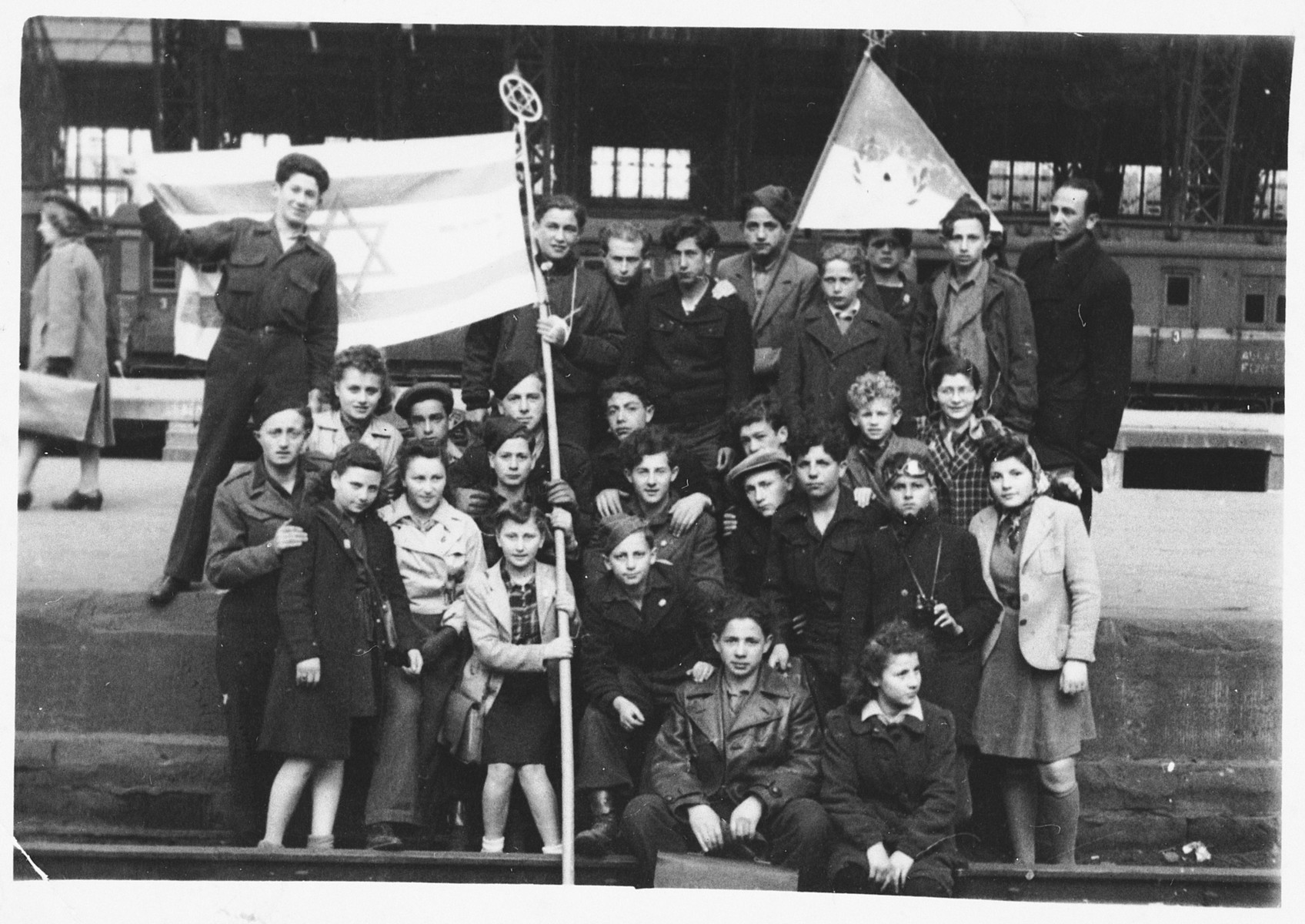 Teenagers from the Zeilsheim children's center pose together with a Zionist flag.

Among those pictured are Eliezer Rosenbach and Shlomo Wacs.