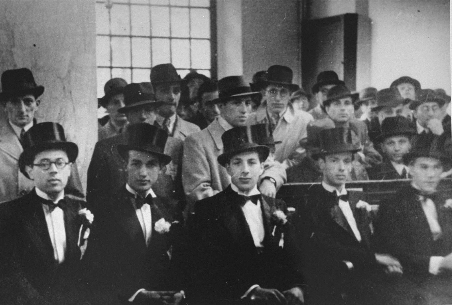 Male attendants at the wedding of Herman de Leeuw and Annie Pais sit in a pew of the Sephardic synagogue in the Jewish quarter of Amsterdam.  

Pictured in the front row, third from the left, is Samuel Schrijver.