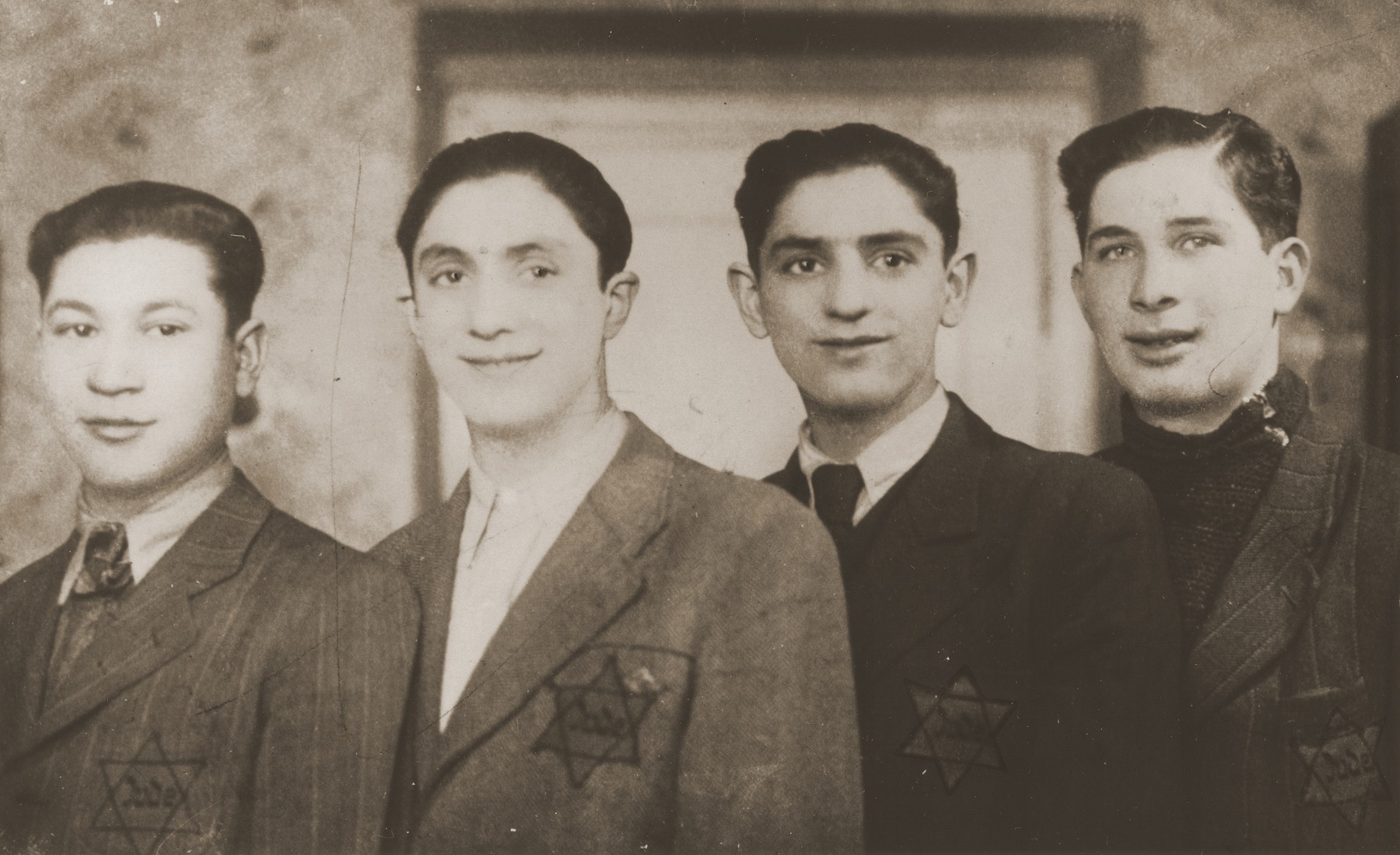 Four teenage boys wearing Jewish badges in Sosnowiec.

Pictured are David and Aaron Jakobowicz (center) with two friends.