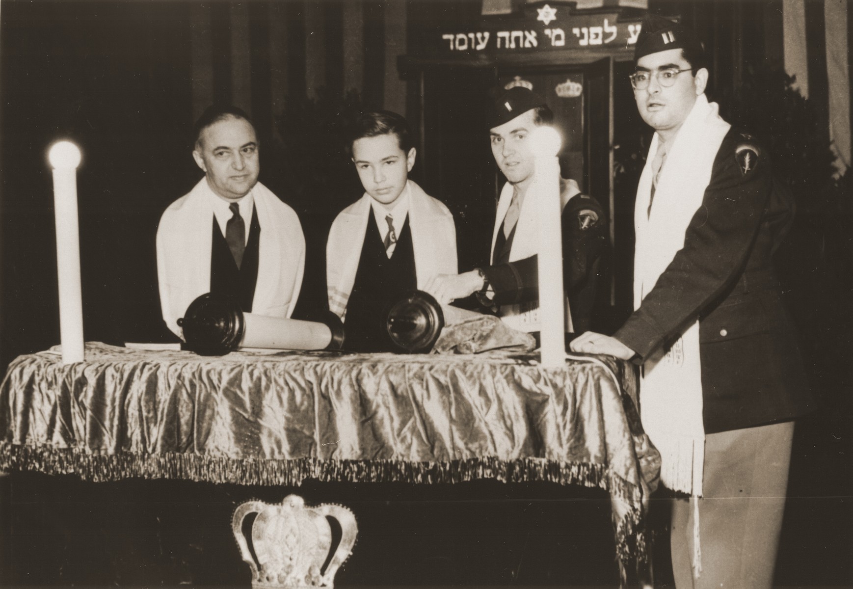 Stephen Bernstein, son of American chaplain Philip Bernstein, reads from the torah at his bar mitzvah at the Philanthropin School in Frankfurt, Germany.

Pictured from left to right are Rabbi Philip Bernstein, Stephen Bernstein, Rabbi Mayer Abramowitz, and Rabbi Herbert Friedman.