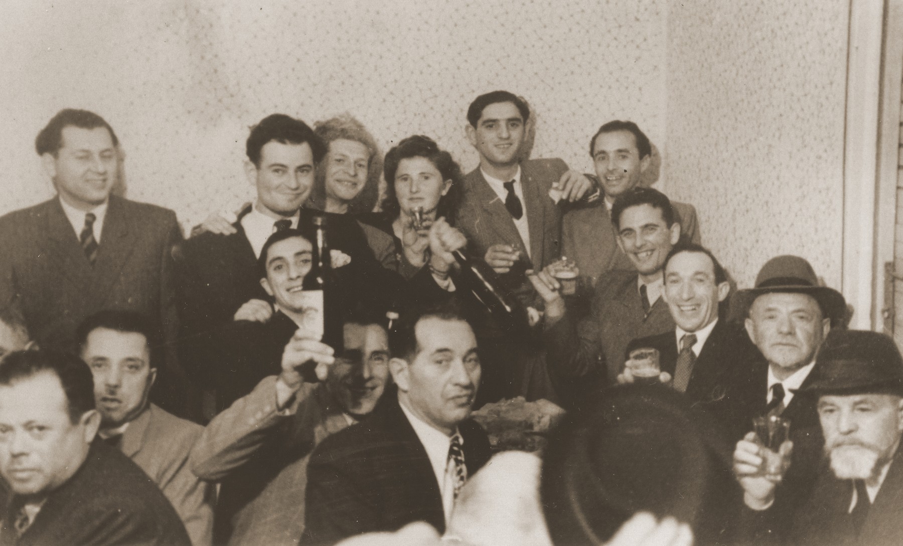 Jews raise their glasses and wine bottles in a toast at a social gathering in Sosnowiec.

Among those pictured are David and Hanka Enzelewicz, and David, Aaron and Joseph Jakobowicz.