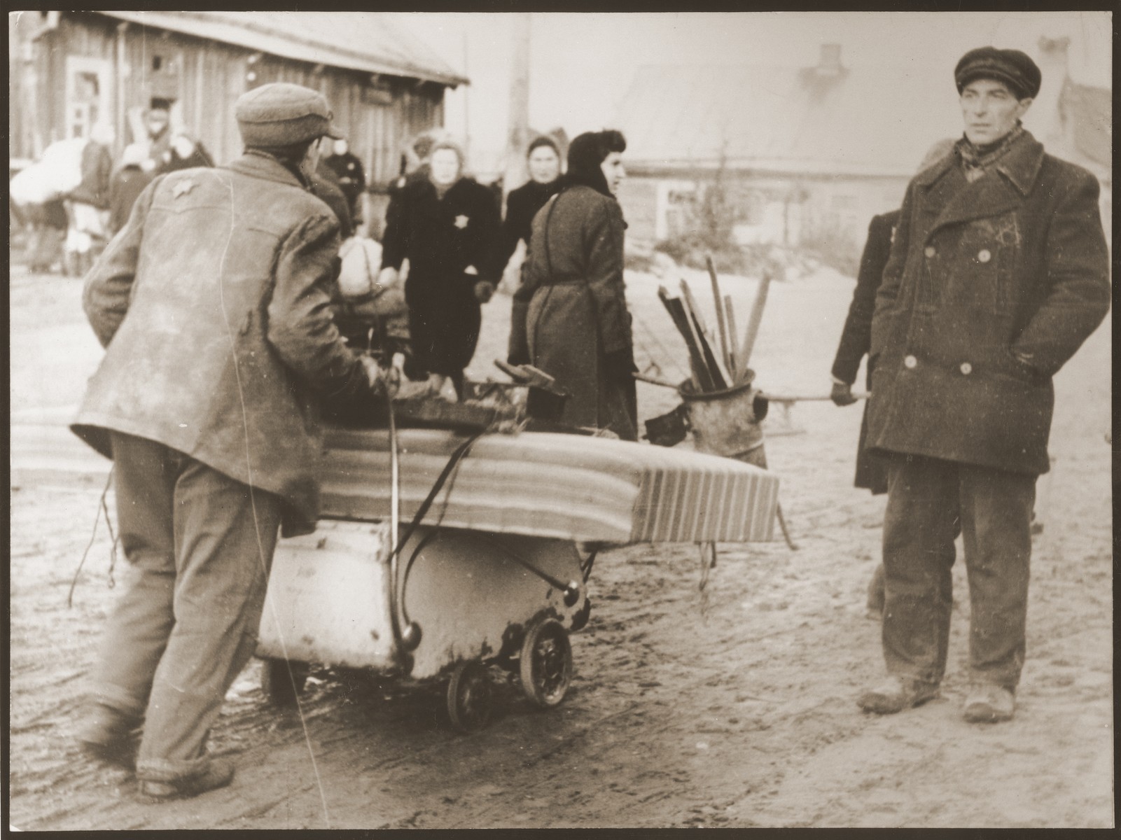 Residents of the ghetto move to new housing after the Germans reduced the borders of the Kovno ghetto.  Since there were no vehicles, these residents are using a baby carriage to transport their belongings.
