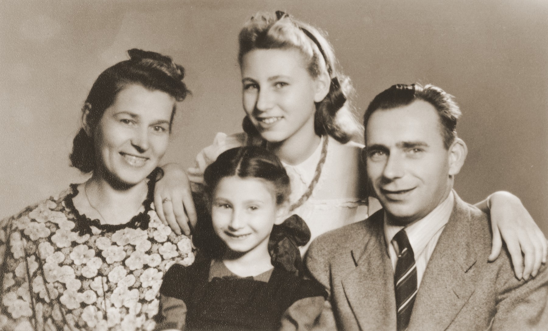 Alicja and Zofja Fajnsztejn, two Jewish sisters in hiding, pose with their rescuers, Helena and Josef Biczyk.  

The picture was taken in the photo studio of the Biczyk's cousin.