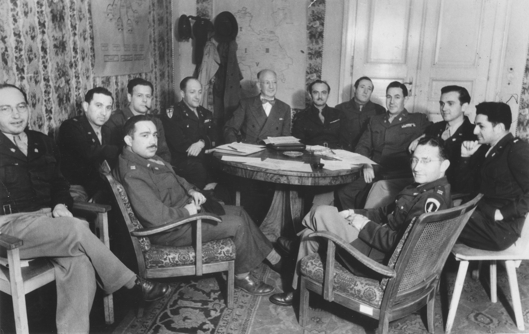 American Jewish army chaplains attend a meeting called by Judge Louis Levinthal, Advisor on Jewish Affairs to the U.S. Army in Germany.  

Among those pictured are Judge Louis Levinthal (with bow tie); Mayer Abramowitz (second from the right, in front of the door); Abraham Klausner (far right); and Oscar Lifschutz (front left in the arm chair).