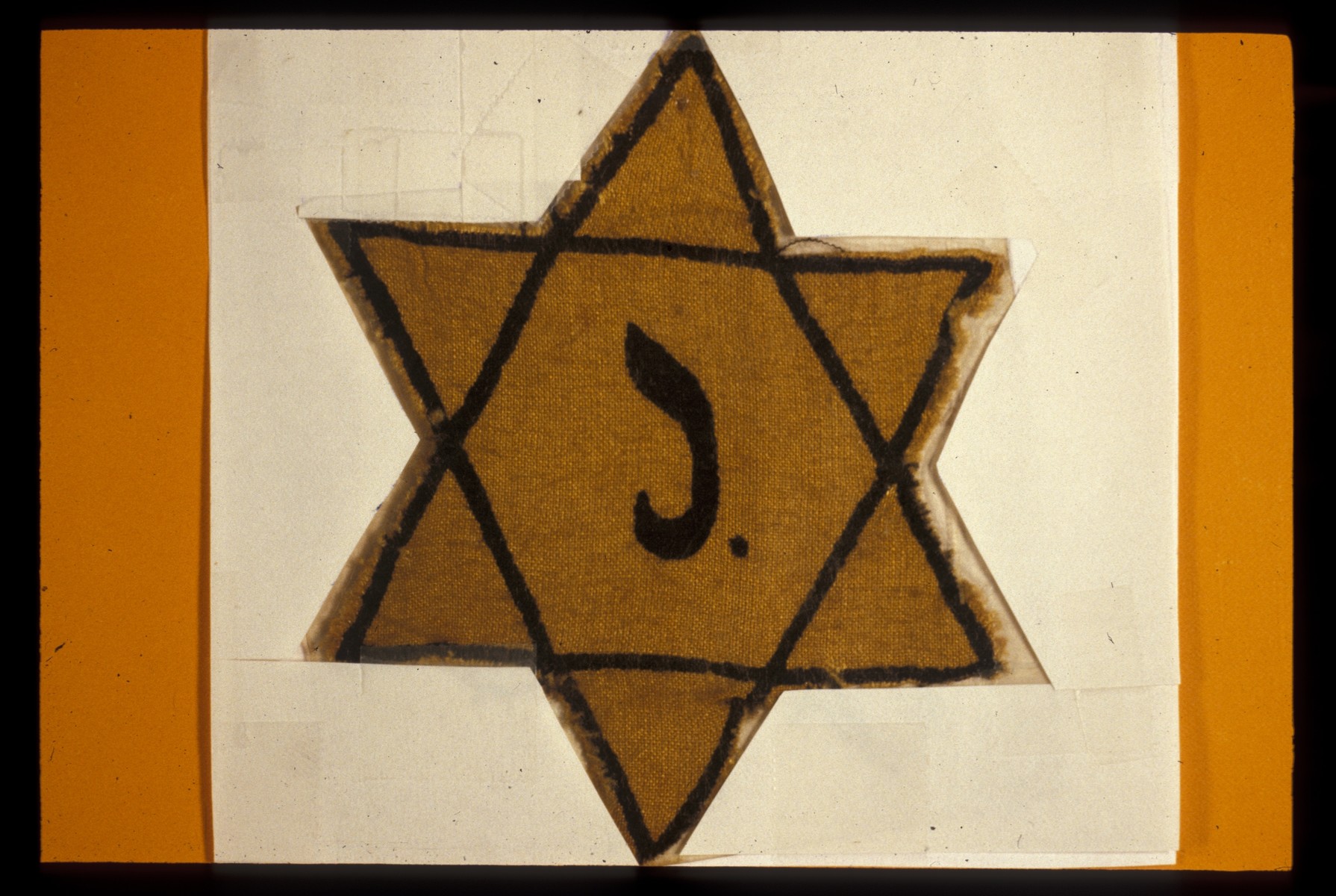 A cloth Star of David stamped with a J for Juif.