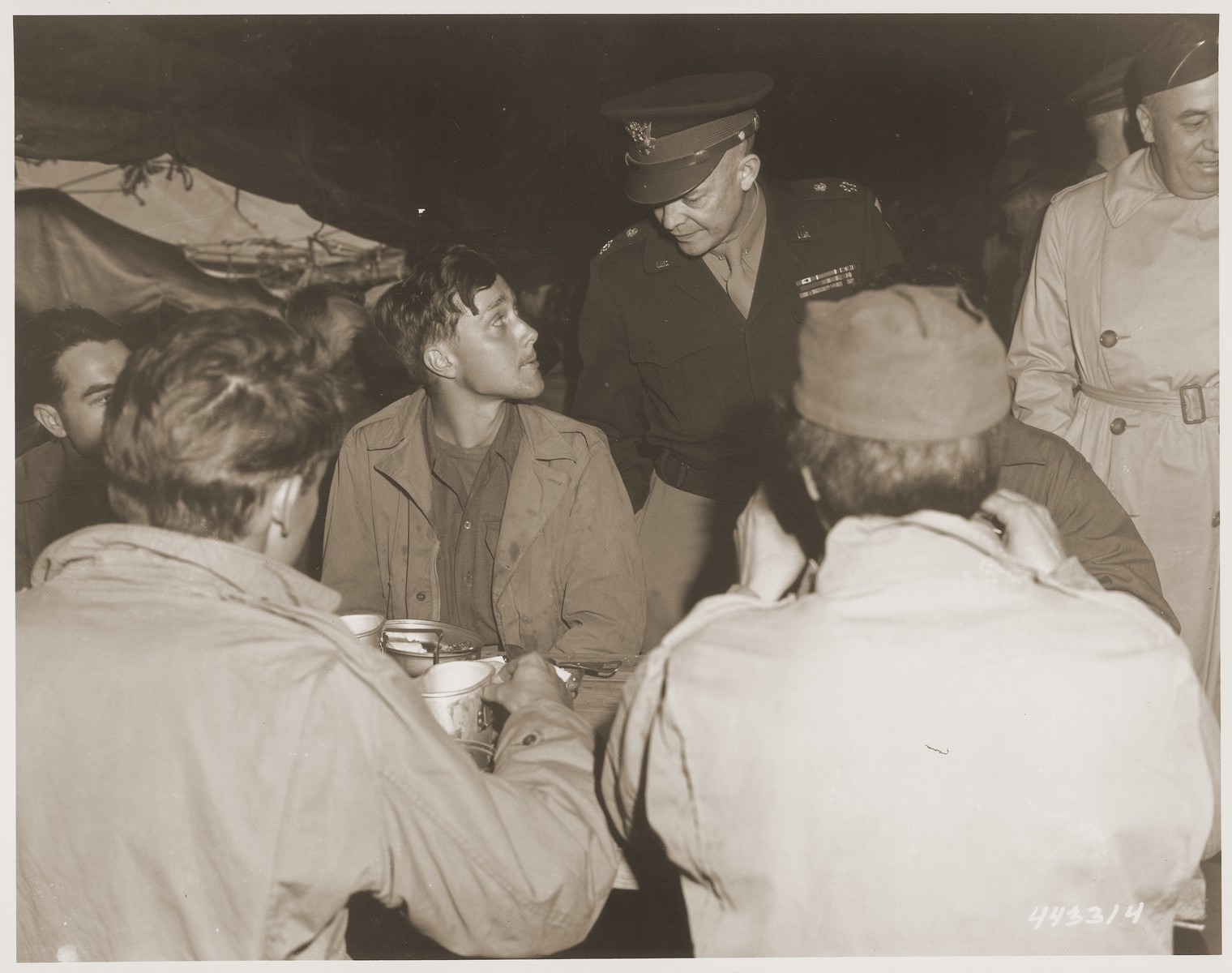 General Eisenhower pauses to speak to Private John D. Hesling of Northeast, Pennsylvania, one of forty thousand American soldiers who became prisoners of war of the Germans.  He is now in a camp in France awaiting transportation to the United States.
