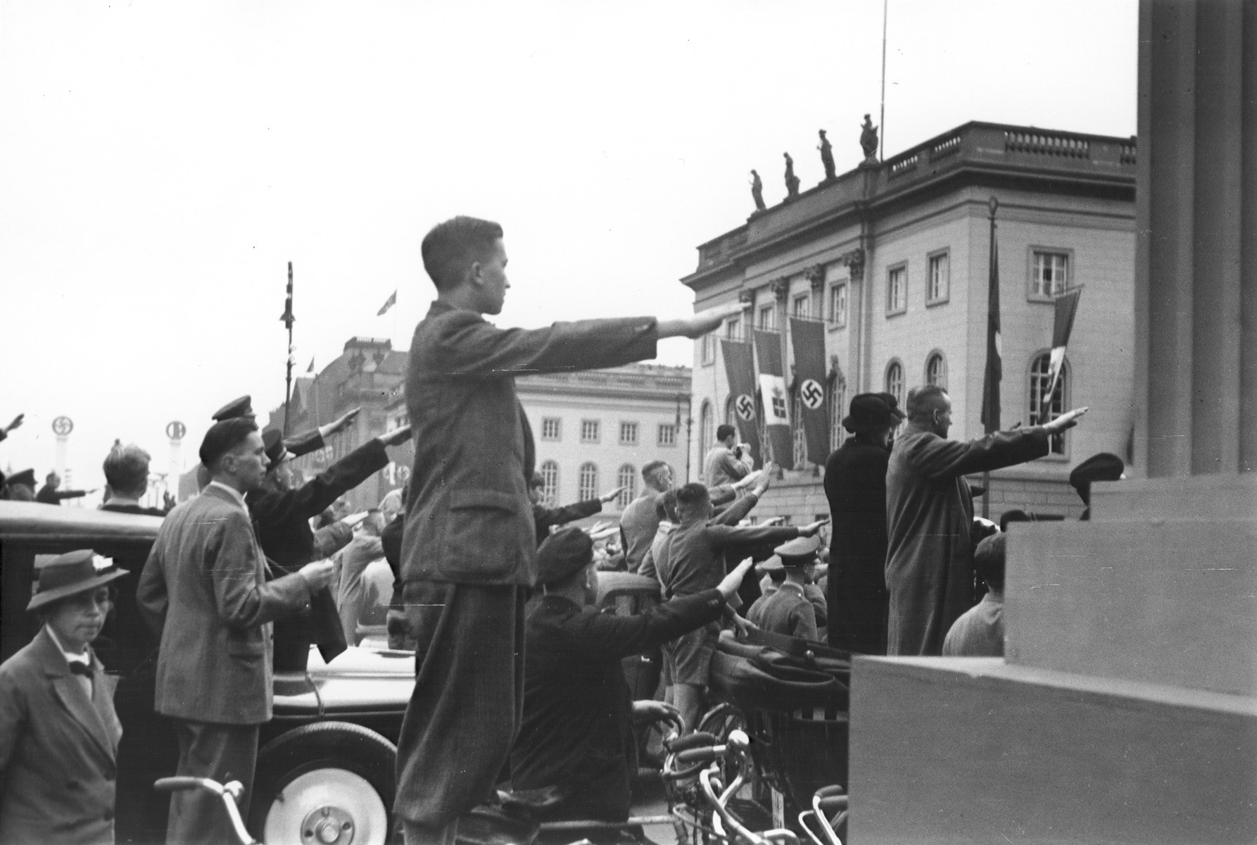 German spectators at a political rally raise their arms in the Nazi salute in Berlin.