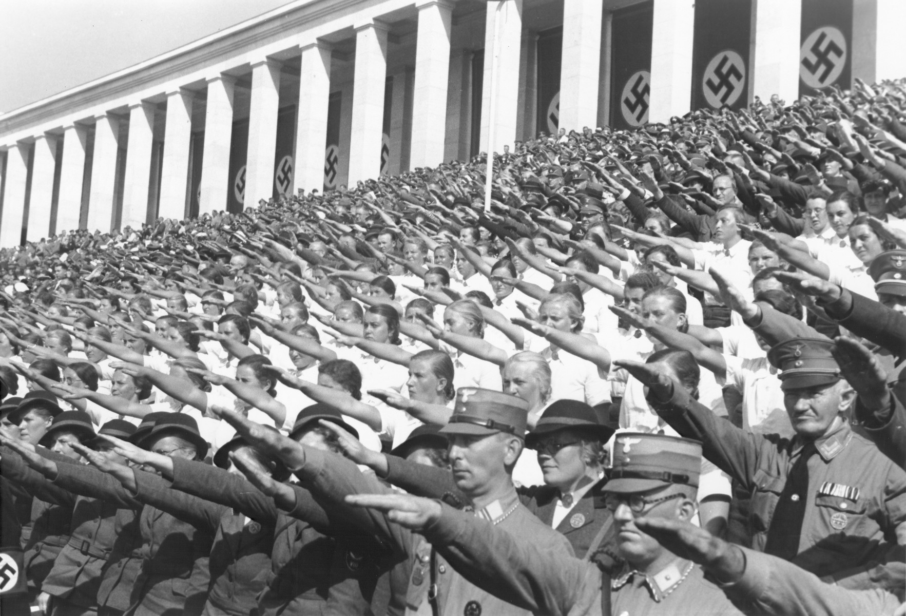 German spectators at the 1937 Reichsparteitag (Reich Party Day) celebrations in Nuremberg raise their arms in the Nazi salute.