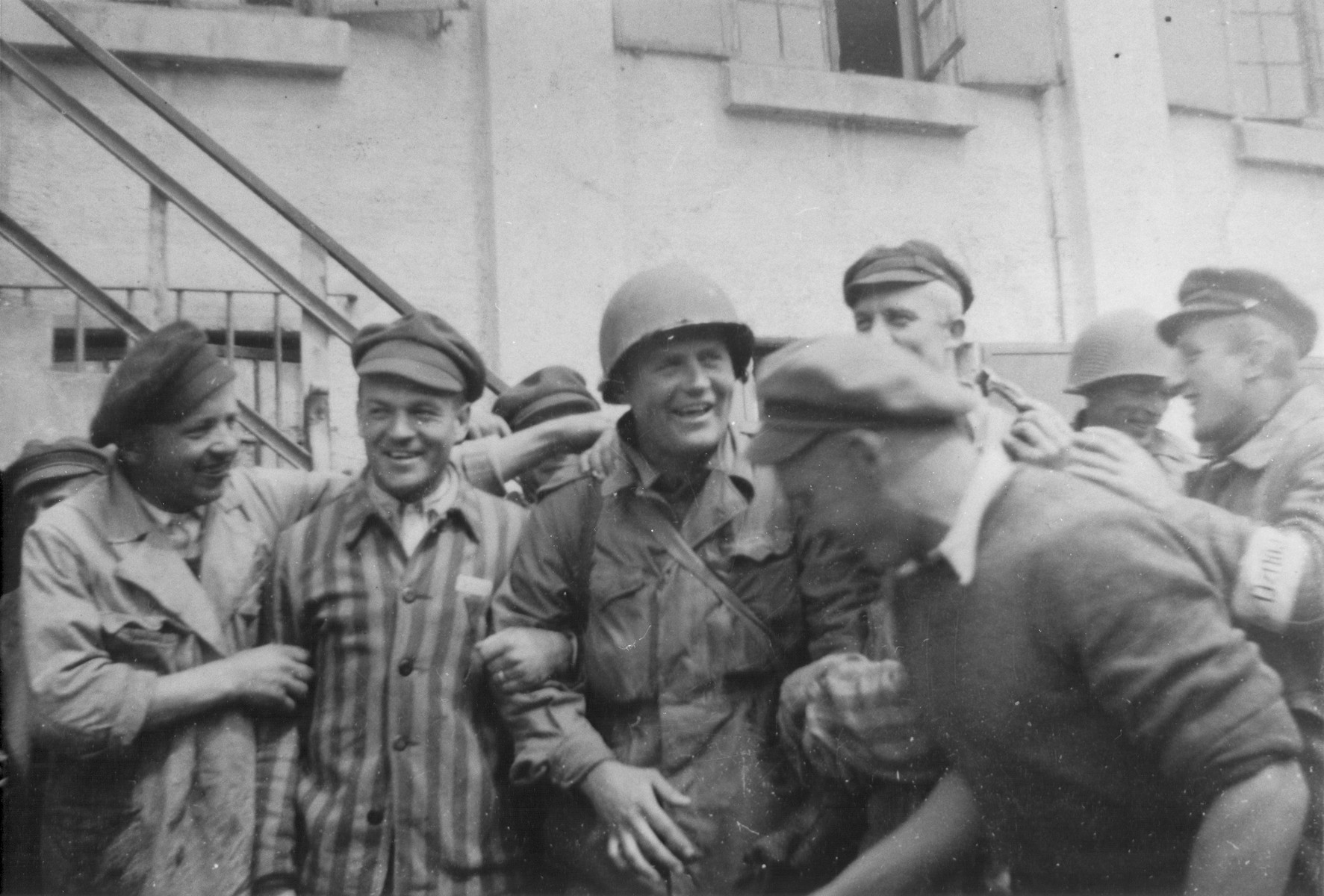 An American officer is surrounded by survivors at the newly liberated Dachau concentration camp.