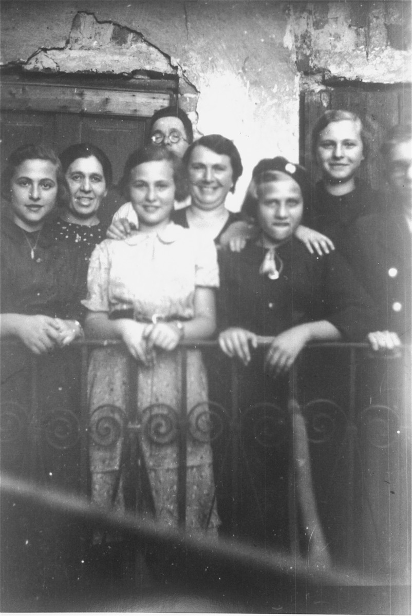Members of the Petranker and Hut families pose on a balcony.

Pictured from left to right are: Amalie Petranker, Klara Hut, Celia Petranker, David Petranker (behind), Frieda Petranker, Paulina Hut, Pepka Petranker, and Jakub Hut.