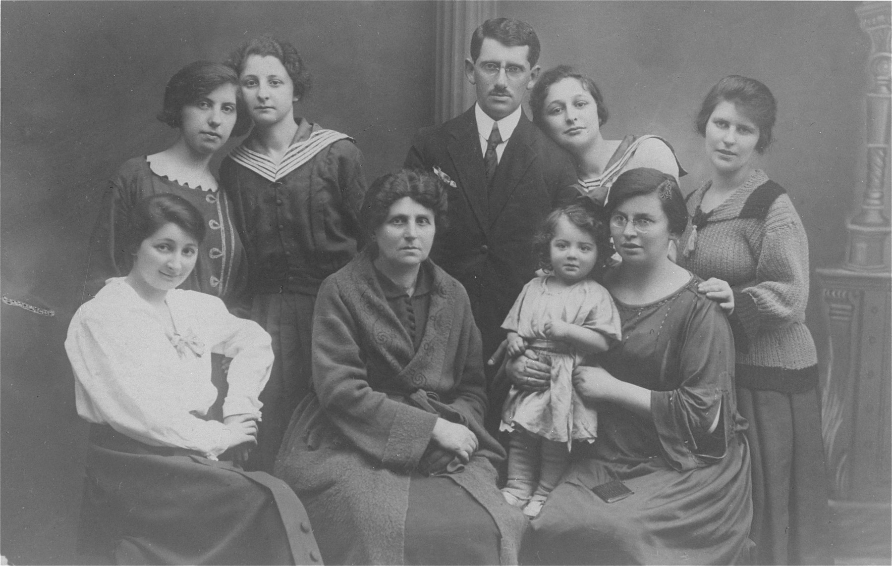 Studio portrait of members of the Laks and Tenenblum families.

Sitting in the front row, from left to right are Anna Tenenblum (Pola's aunt), Sara Tenenblum (Pola's mother), and Pola (Tenenblum) Laks holding her baby Hania Laks.  Standing in the back row from left to right are: Dora Laks (Isaac's sister), Rozia Tenenblum (Pola's sister), Isaac Laks, Regina Tenenblum (Pola's sister) and Lodzia Laks (Isaac's sister).  Only Dora and Hania Laks survived the war.