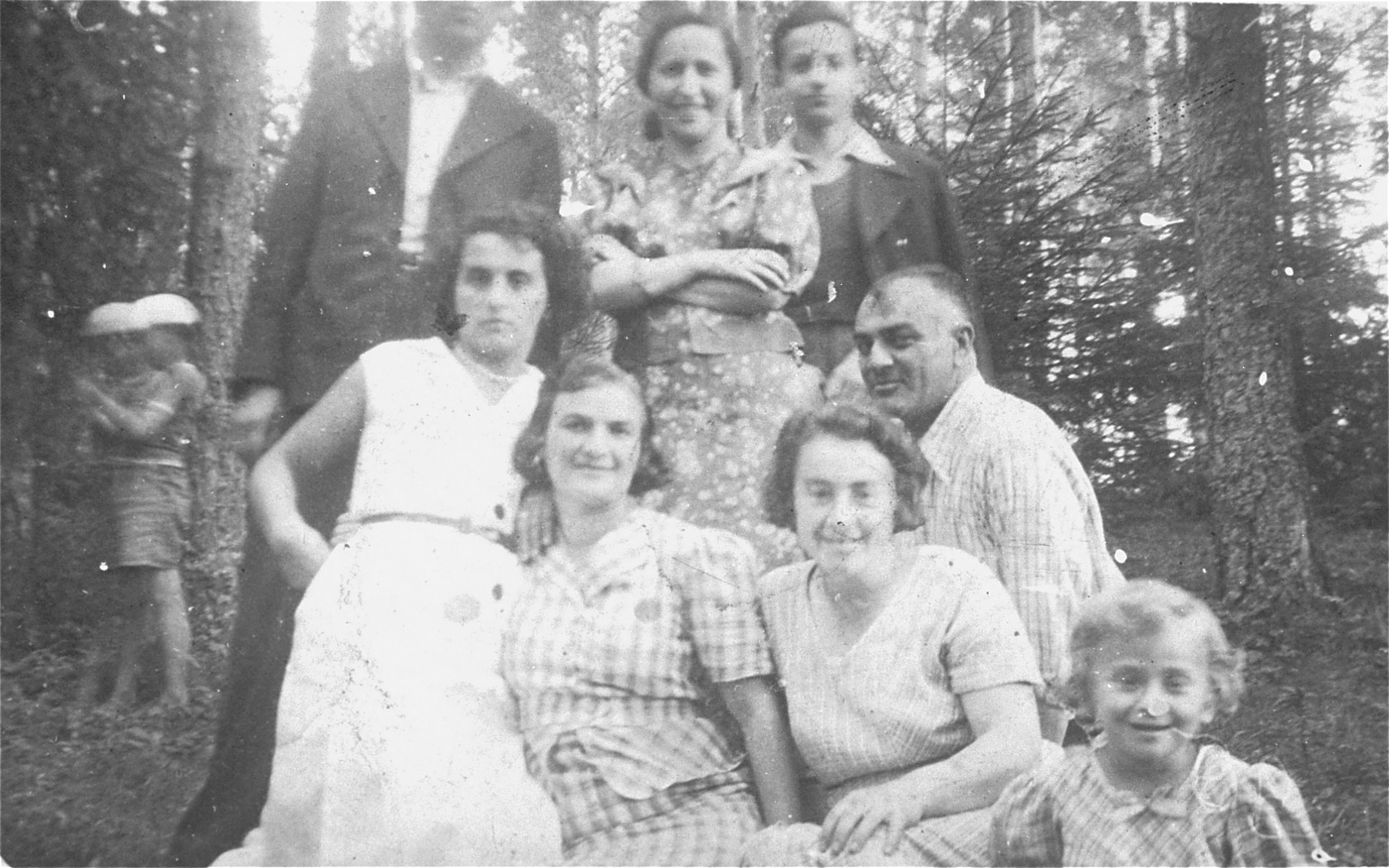 Friends and relatives of a Jewish family from Sejny pose for a group portrait in the woods.

Pictured are relatives of the Szczupacki family.