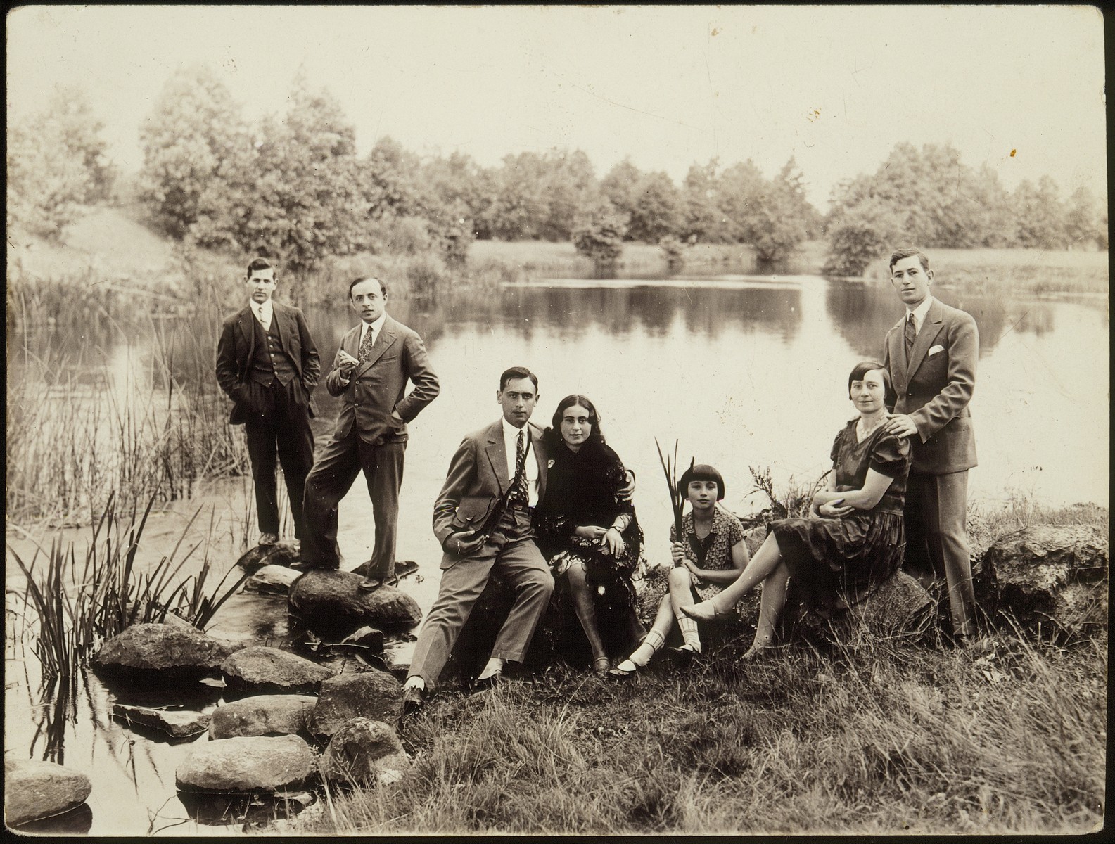 Members of the Kudlanski and Dubrowicz families pose on the shore of a lake near Eisiskes.

Among those pictured are Hanneh-Beile (Moszczenik) Kudlanski (second from the right), her daughter Atara Kudlanski, Leah Dubrowicz and her brother Shaul Dubrowicz.  The Kudlanski family immigrated to America; the Dubrowiczes perished during the Holocaust.