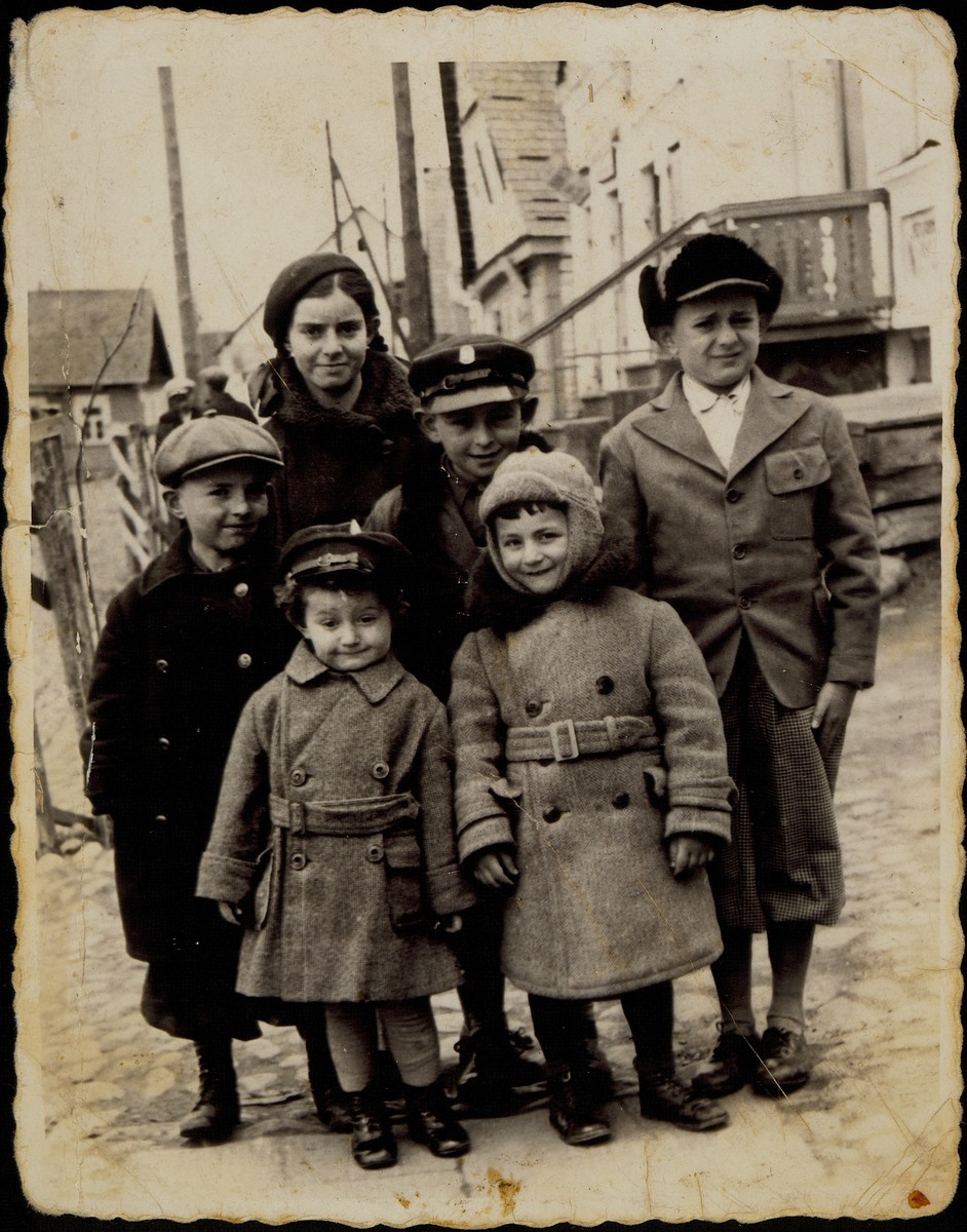 Benyamin Sonenson poses for a bar mitzvah portrait with his cousins only days before the massacre of Eisiskes' Jewish population.

Benyamin Sonenson's bar mitzvah in September 1941 was the last one to be celebrated in Eisiskes.  Standing near the house of Alte Katz are (right to left) Benyamin, Yitzhak Sonenson, Altke Tawlitski, and Hayyim Tawlitski.  Standing in the front are Meir Sonenson (right) and Oscar (Asher) Shereshefski.  

Yitzhak survived in hiding, Oscar survived in Siberia; all the others were murdered by the Germans during the September 1941 mass shooting action in Eisiskes