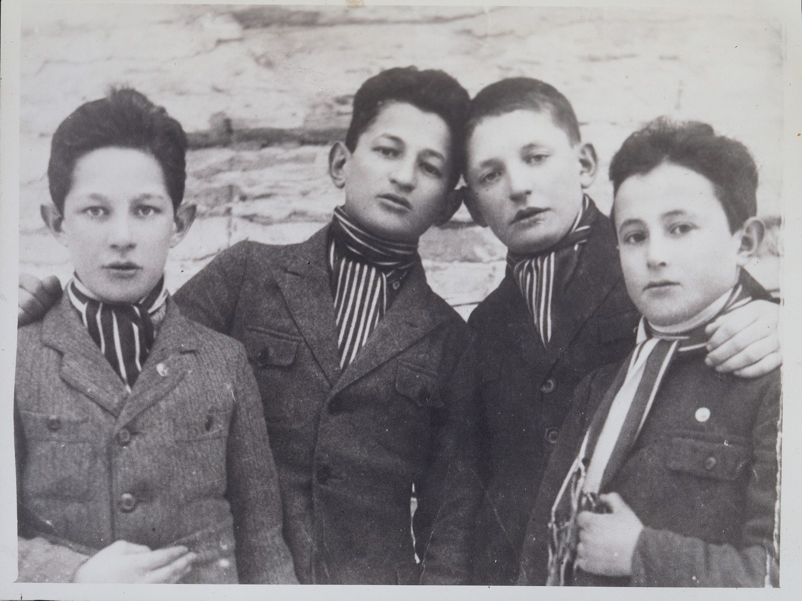 Four Jewish teenage boys from Eisiskes pose wearing striped cravats, indicating they were members of the soccer team.

Pictured from right to left are: Velvke Saltz, Motke Kiuchefski, Leibke Sonenson and Israel Szczuczynski.  Velvke Saltzs immigrated to the United States in 1923; Motke Kiuchefski fled to the Soviet Union; Leibke Sonenson was killed by the Germans in the September 1941 mass shooting action in Eisiskes; and Israel Szczuczynski was killed by members of the Polish Home Army.