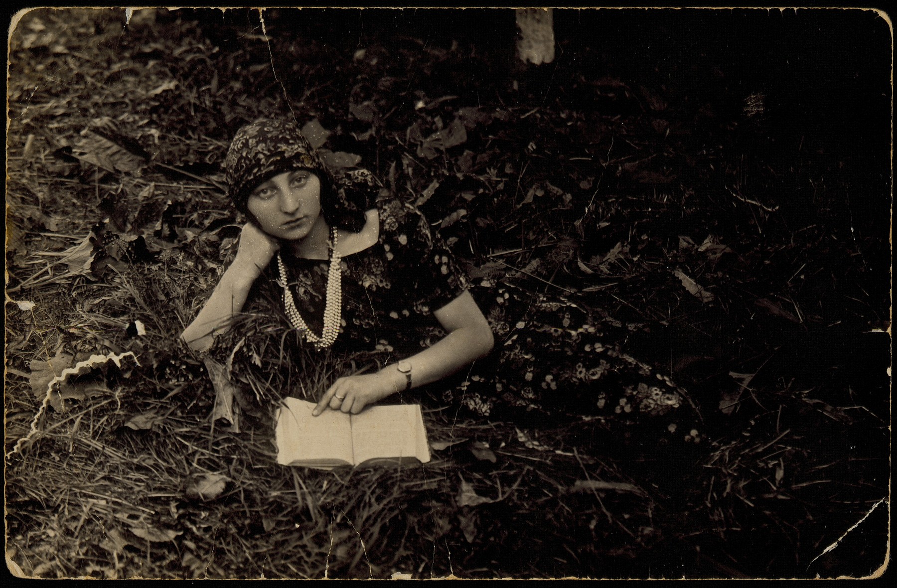 Zipporah Katz (Sonenson), one of the shtetl Hebrew librarians, reads a book while lying in a field.

Zipporah was murdered by the Polish Home Army on October 20, 1944. The inscription on the back of the photo reads, "Leahle remember your friend Feigele (Zipporah)".