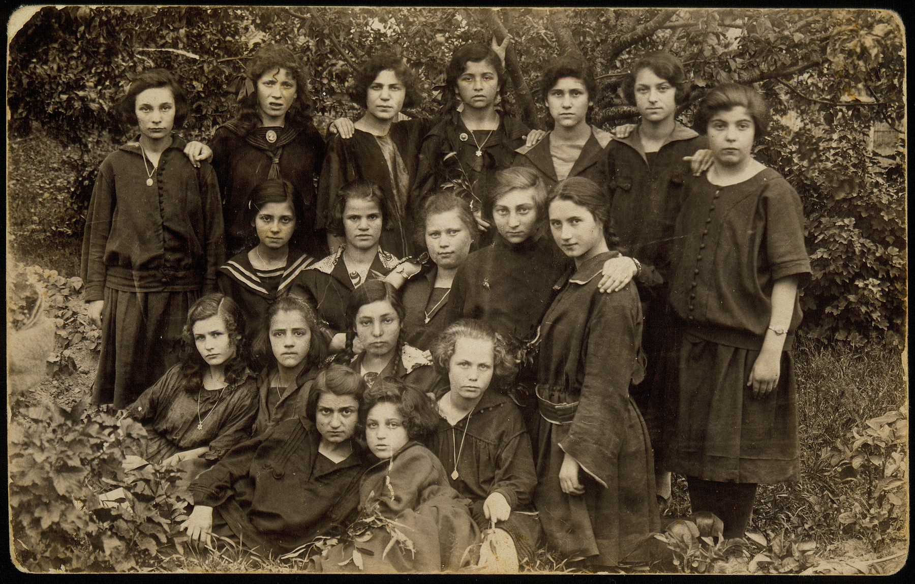 Group portrait of teenage girls beloning to a social group known as the 21 Club. 

In 1921, twenty-one teenage girls, all Hebrew students established an apolitical friendship society and named it  Club 21.  Their younger sisters decided to establish a similar club, simply named Our Circle.  Many of these young women emigrated or moved to larger towns during the 1930s. 

Among the Club 21 members: Mattle Sonenson (front right) and her best friend Geneshe Kaganowicz; Zipporah Katz (third row, second from right);  Leah Koppelman (top row, fourth from right).