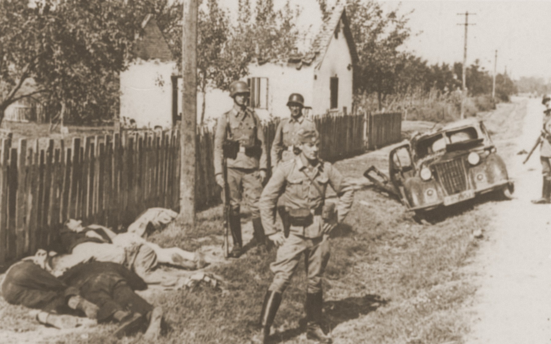 German police stand near the bodies of recently executed Serbian civilians.
