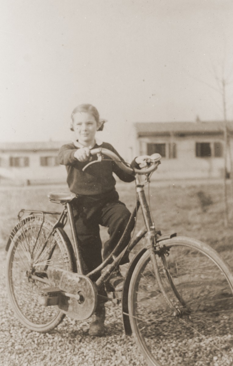 Marie Genevieve Pamentier at the Recebedou camp.

Marie Genevieve Parmentier was a ten year-old French girl living in Paris at the time of the German occupation in 1940. Her widowed mother sent her to safety with an old relative in Ariège in the South of France. She sooned joined her aunt, Isabelle Peloux, a military nurse, at the camp of Recebedou. While there she attended primary school at nearby Portet-sur-Garonne, before returning to her family in the summer of 1941.  The bicycle, given to her by her grandmother, helped her get to school at Portet-sur-Garonne.