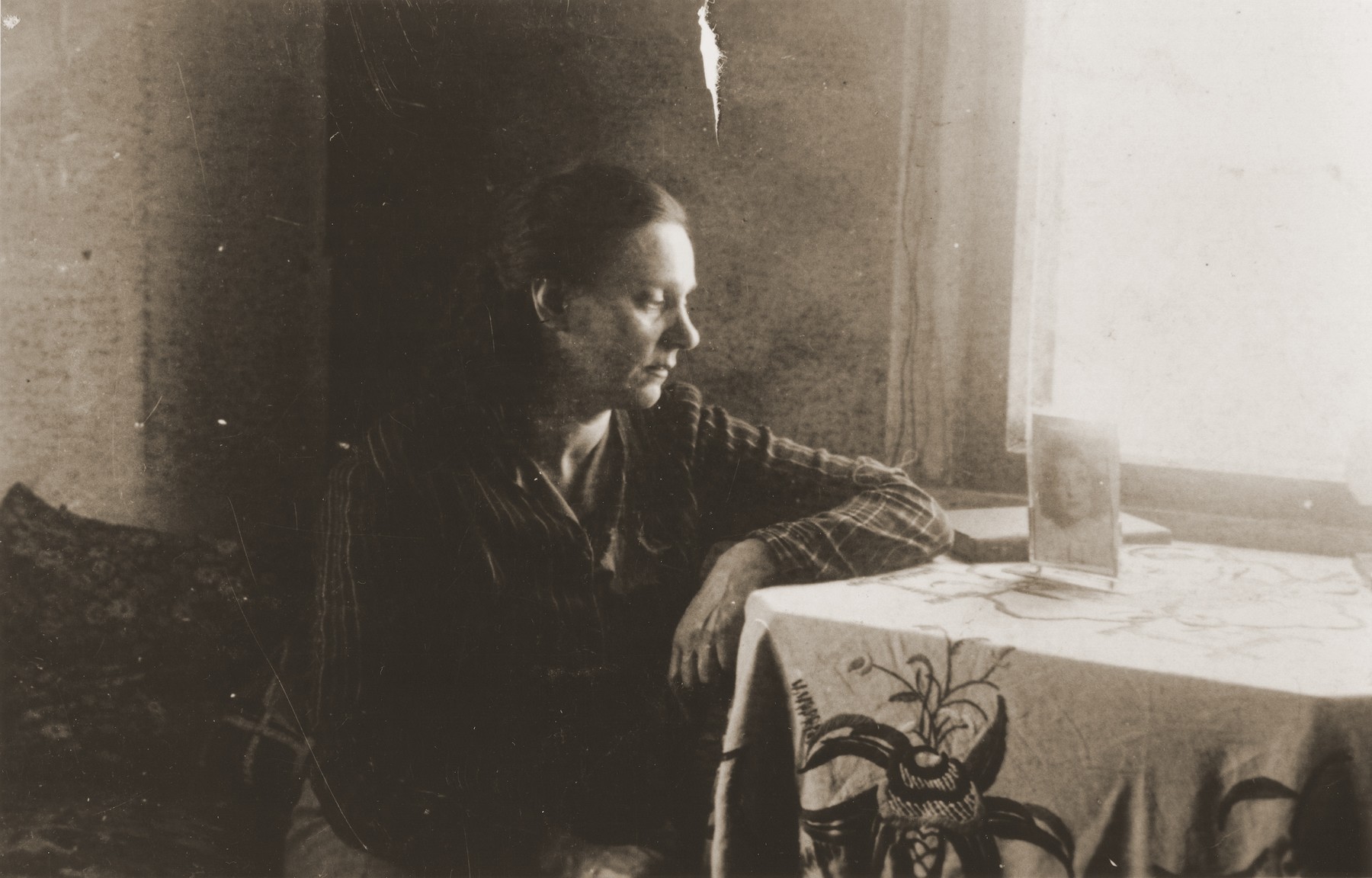 Zoia Bershtanski sits at a table in her room in the Kovno ghetto.

Zoia Bershtanski lived with her married sister, Meri Karnovski, in the ghetto.  Both died in a bunker when the Germans set the ghetto on fire in July 1944.  The photographer, David Ratner, was a friend and a member of the Communist underground.