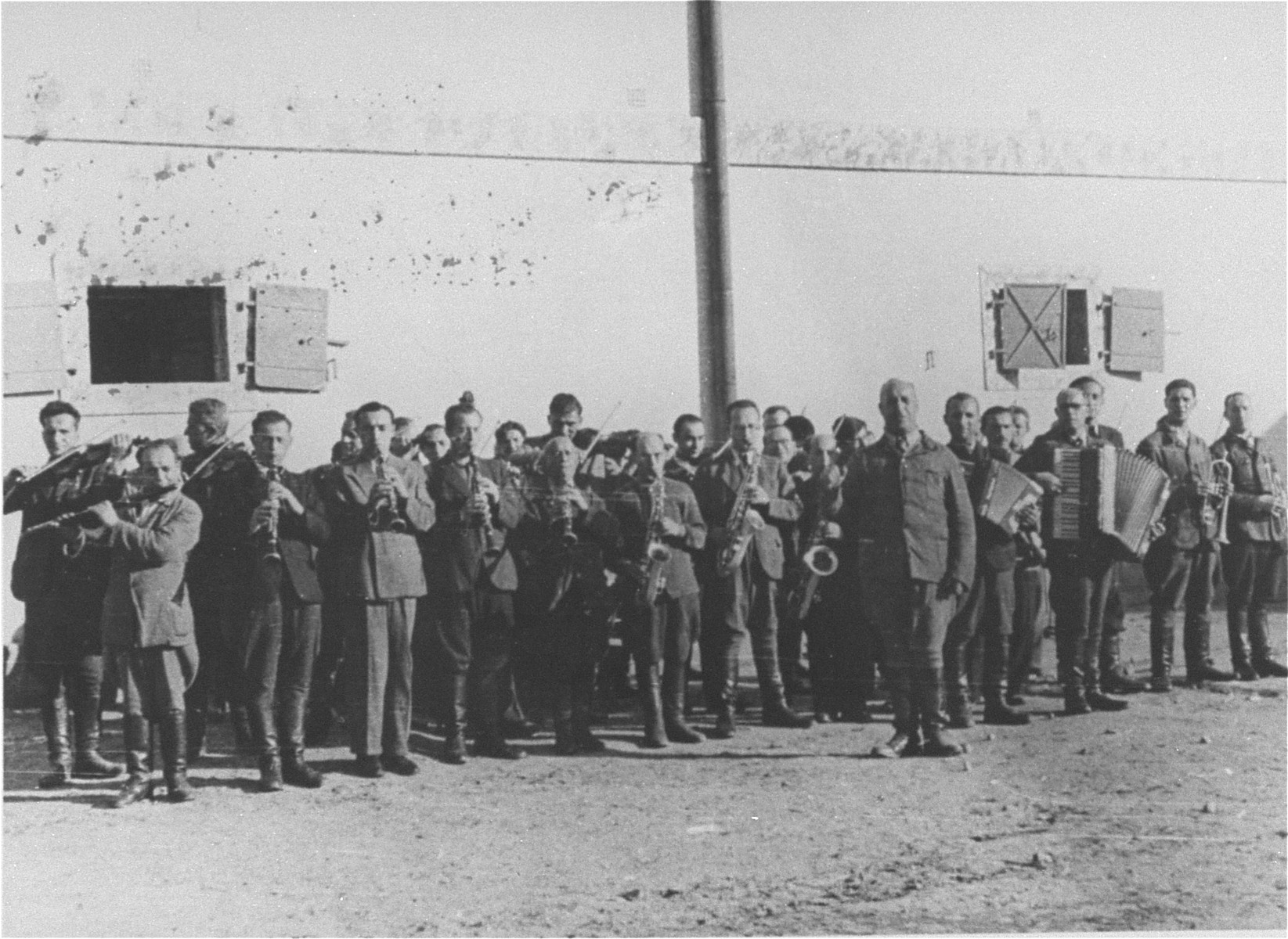 Members of the camp orchestra perform in front of a barracks in the Janowska concentration camp.

The Janowska orchestra included some of the leading Jewish musicians in Lvov, among them violinist Leonid Stricks and cellist Leon Eber.  The SS forced the orchestra to perform during selections and actions and even "commissioned" a special composition to be played on these occasions.  Entitled "Todestango" [Tango of Death], the piece was composed by Yakub Munt (sp?), former director of the Lvov opera.  The music was based on an earlier work by Eduardo Bianco.  The members of the orchestra met their end in 1943 when they were shot to death by their overseers while playing their instruments.