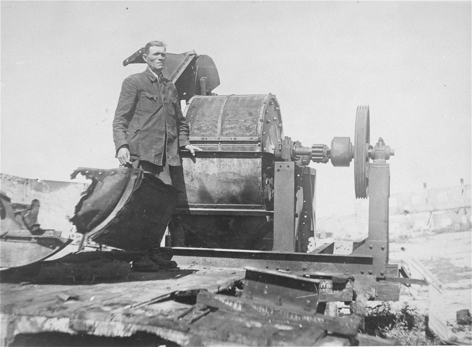 Moses Korn, a Jewish prisoner forced to work in Sonderkommando 1005 unit, poses next to a bone crushing machine in the Janowska concentration camp.

This photograph ws taken soon after liberation for the Extraordinary Commission or the Red Army.