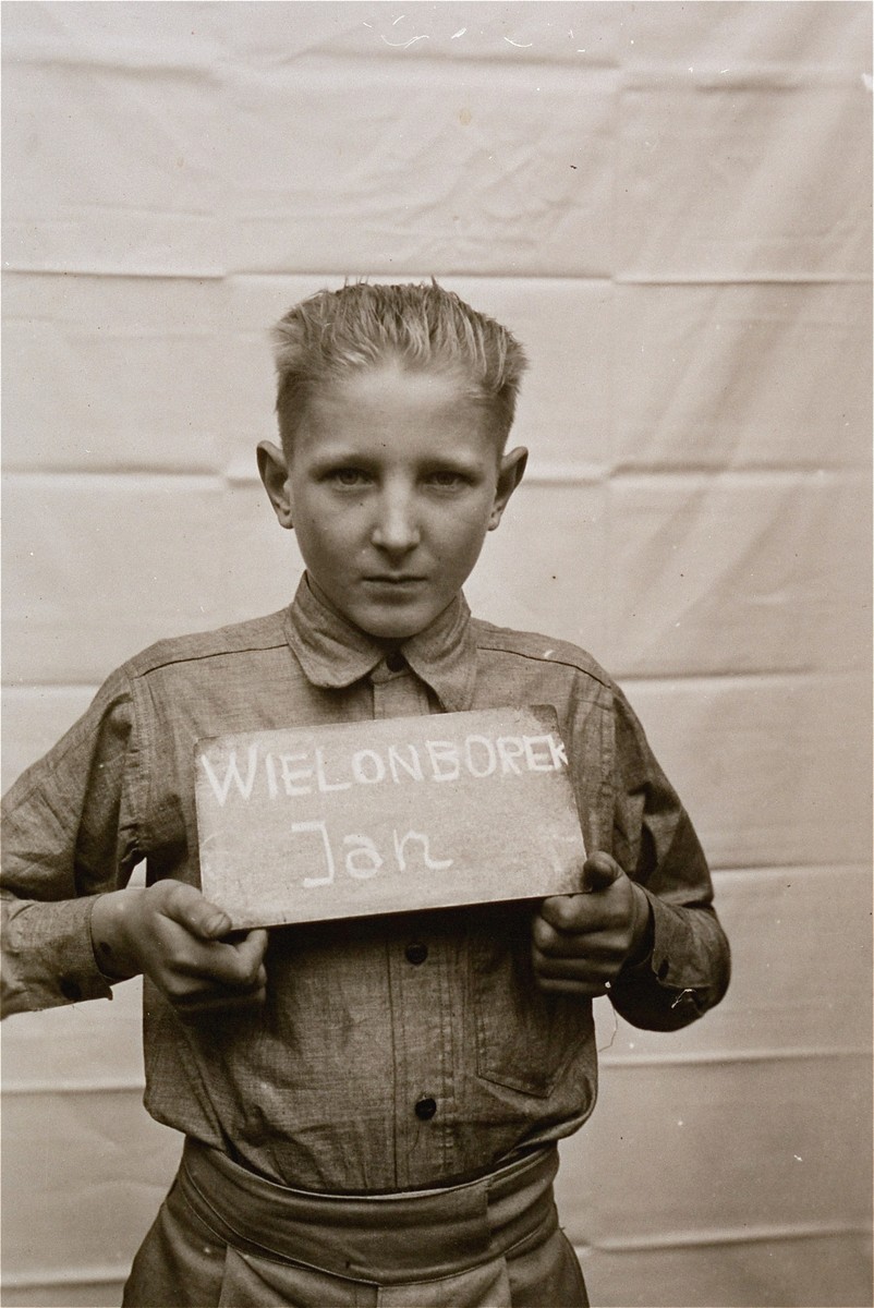 Jan Wielonborek holds a name card intended to help any of his surviving family members locate him at the Kloster Indersdorf DP camp.  This photograph was published in newspapers to facilitate reuniting the family.