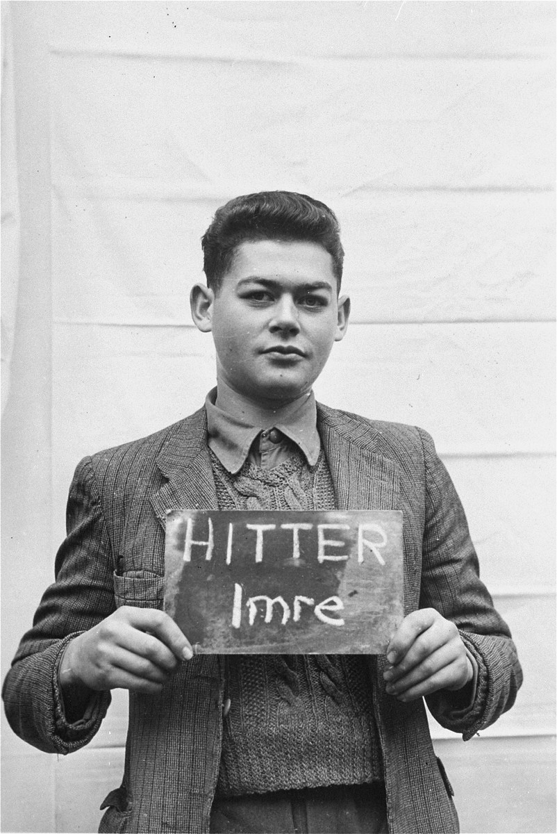 Imre Hitter holds a name card intended to help any of his surviving family members locate him at the Kloster Indersdorf DP camp.  This photograph was published in newspapers to facilitate reuniting the family.