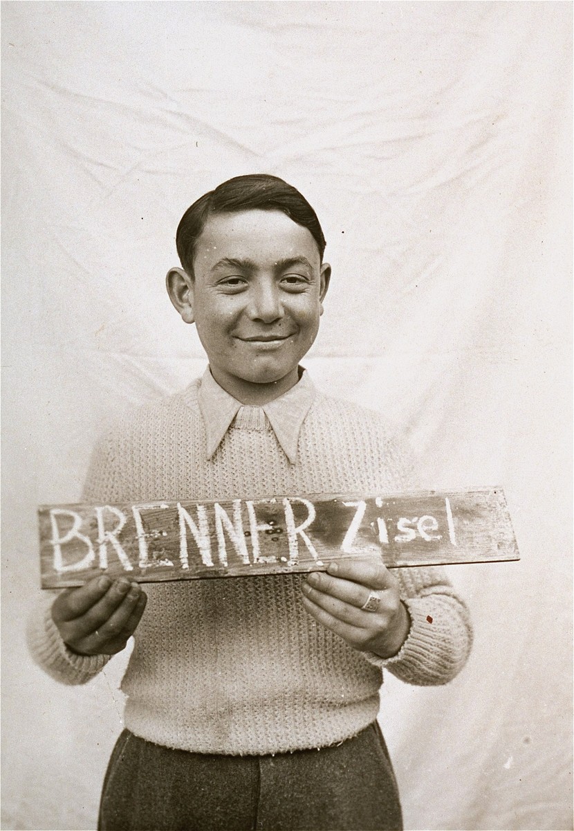 Zisel Brenner holds a name card intended to help any of his surviving family members locate him at the Kloster Indersdorf DP camp.  This photograph was published in newspapers to facilitate reuniting the family.