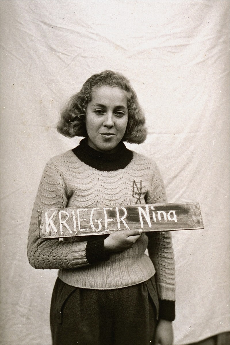 Nina Krieger holds a name card intended to help any of her surviving family members locate her at the Kloster Indersdorf DP camp.  This photograph was published in newspapers to facilitate reuniting the family.