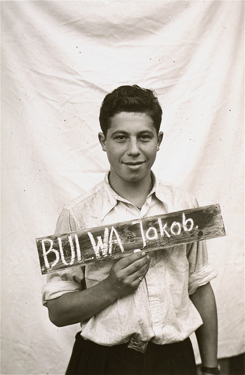 Jakob Bulwa holds a name card intended to help any of his surviving family members locate him at the Kloster Indersdorf DP camp.  This photograph was published in newspapers to facilitate reuniting the family.