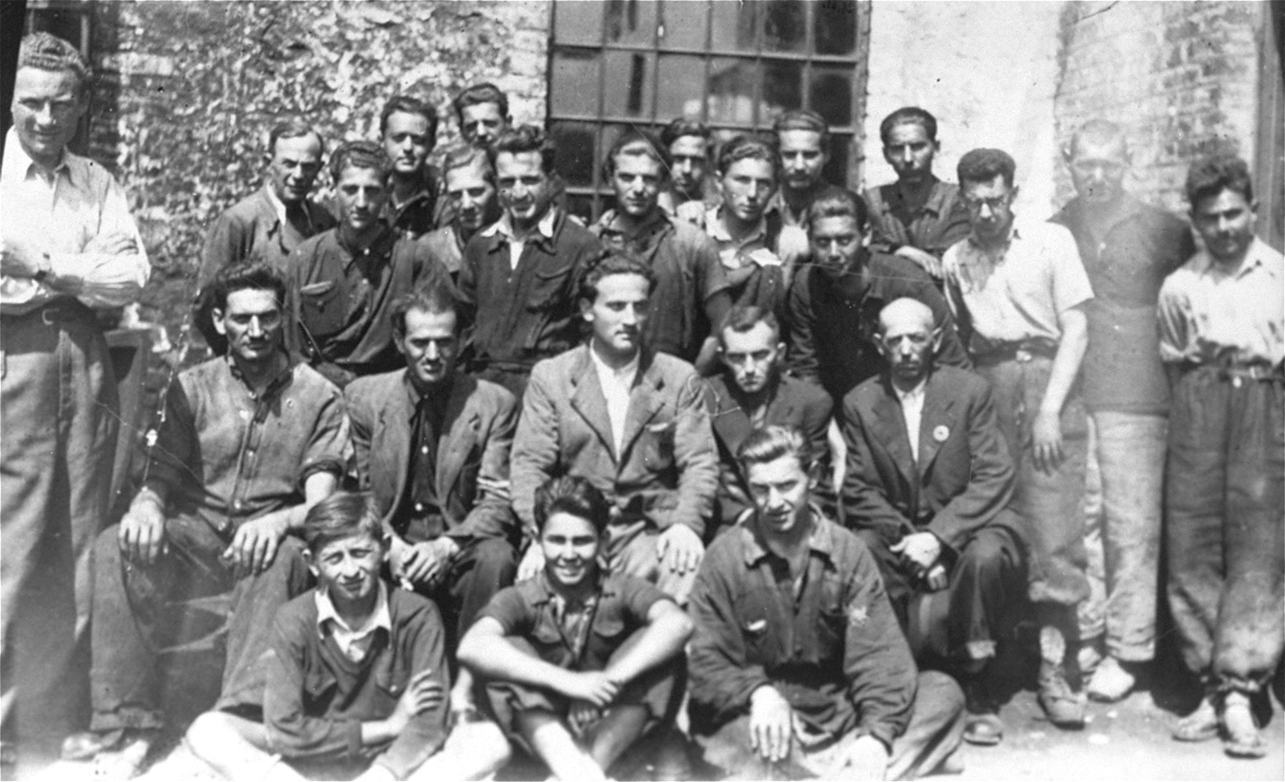 Group portrait of Jewish forced laborers at the Turnatoria, the machine shop established by Siegfried Jagendorf in the Mogilev-Podolskiy foundry.

Pictured in the center is Max Schmidt, an engineer from Cernauti who headed the lathe and power plant department of the Turnatoria.  Also pictured is Max Auslander (standing in the back row, seventh from the left). Friedrich Haas is pictured sitting in the front row center.  Seated in the second row on the far right is the manager, Engineer Josef Schmidt.