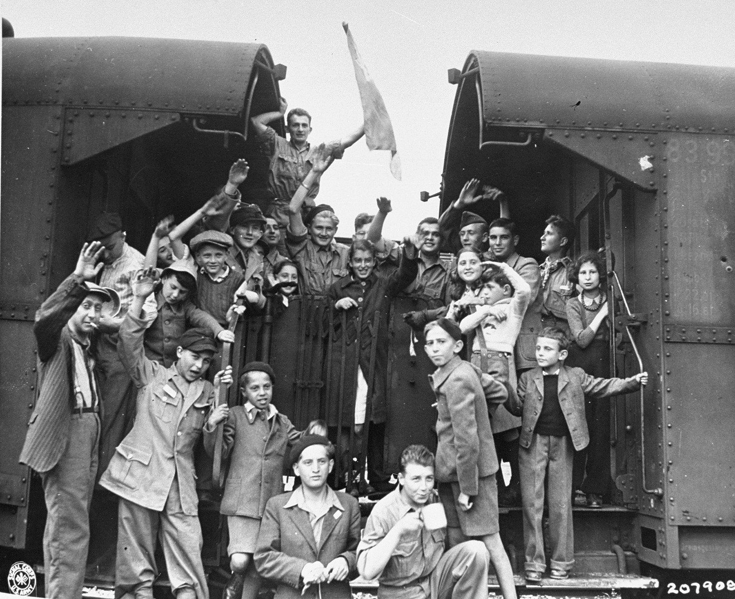 A group of Jewish children wave goodbye as they depart by train from the Buchenwald concentration camp. 

The original caption reads, "A group of Jewish children wave good bye to friends at the Buchenwald concentration camp.  They have been recently released and are on their way to France; from there some will go to Palestine, some to the U.S."