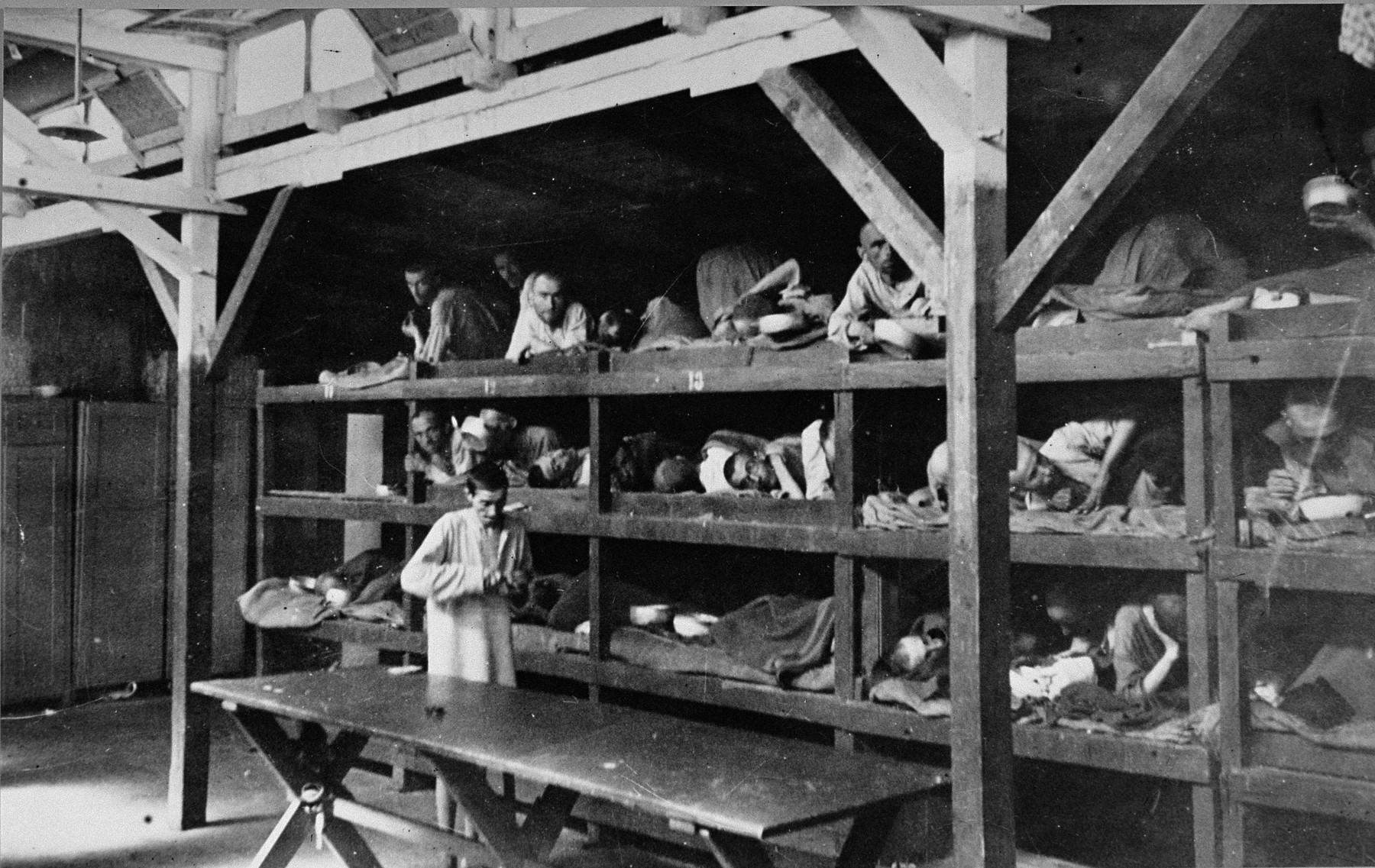 Survivors lie in multi-tiered bunks in a barracks in the newly liberated Buchenwald concentration camp.

The original caption reads "Here is a Nazi hospital ward in Buchenwald concentration camp.  The sick prisoners who were still able to move about cared for those in the cribs."