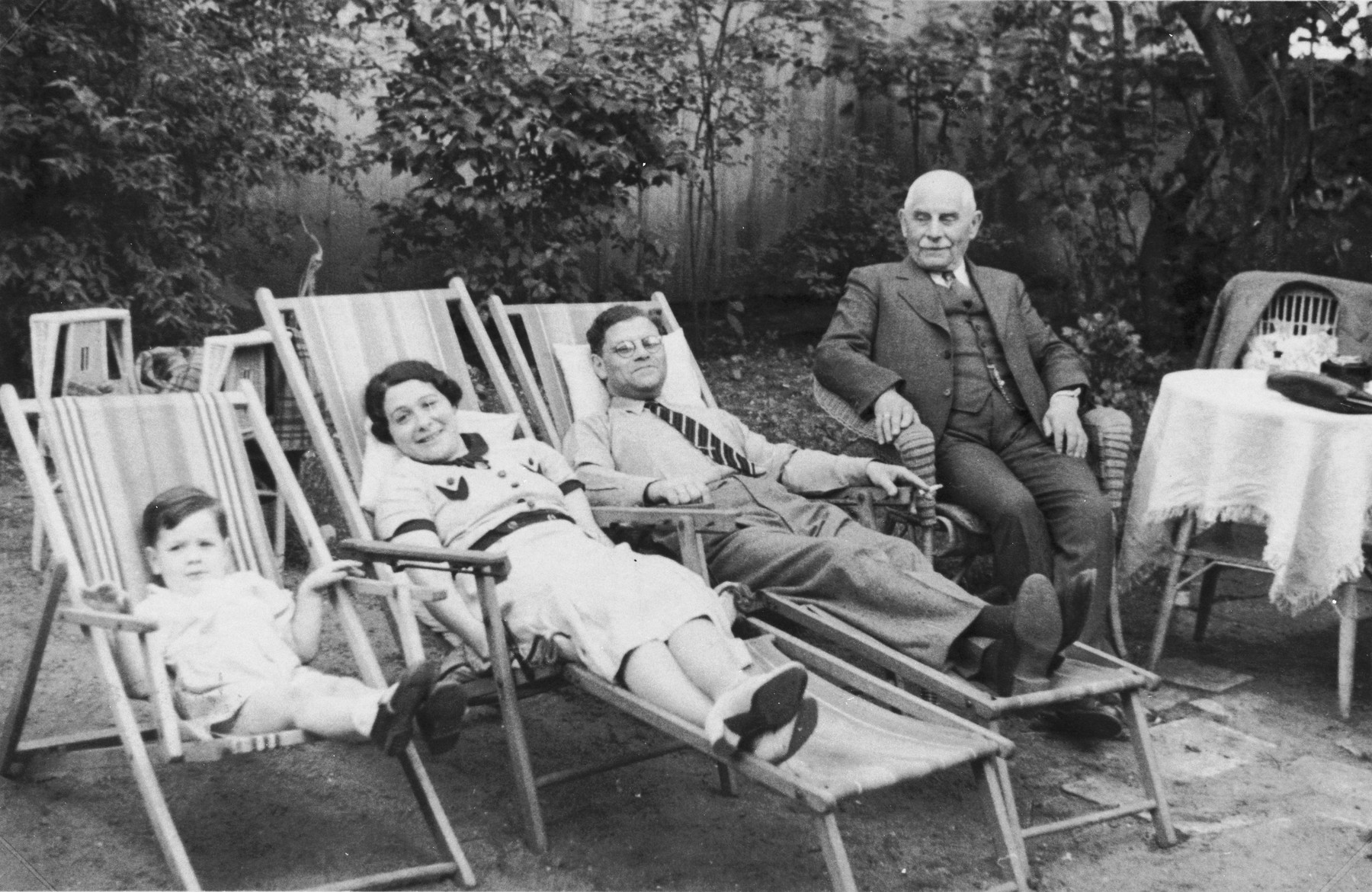 The Jacobsohn family relaxes outside on lawn chairs.

Pictured from left to right are: Rudolf, Margaret and Erich Jacobsohn and Erich's father, George Jacobsohn.