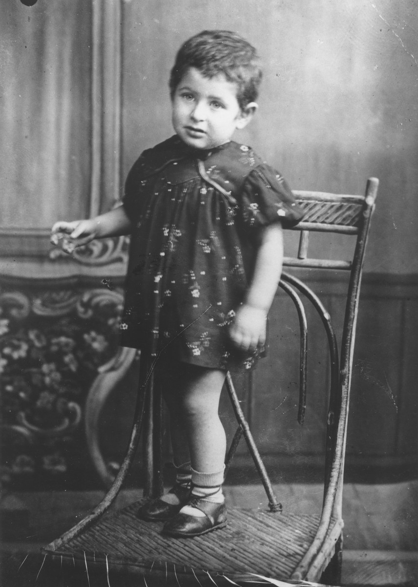 Studio portrait of a Jewish child posing on a chair in Sverdlovsk.

Pictured is Frieda Rudashevsky, the cousin of donor Cilia Rudashevsky, who was born in prison in Sverdlovsk.  Frieda's family returned to Vilna before the German occupation and she perished in the Vilna ghetto.
