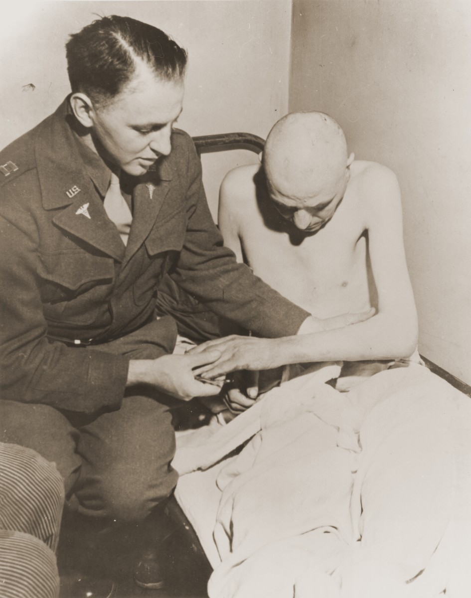 An American doctor examines a Soviet survivor at the Dortmund prisoner-of-war camp in Germany.